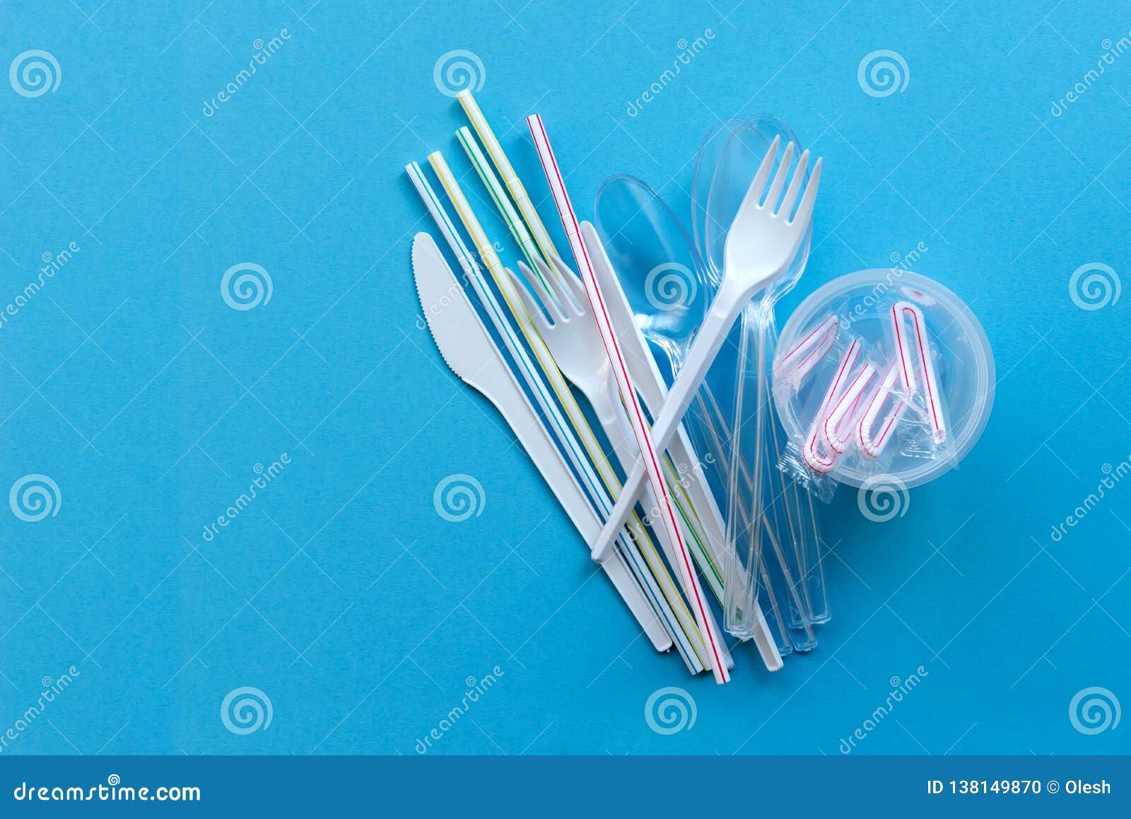 white single-use plastic and plastic drink straws on a blue background. say no to single use plastic