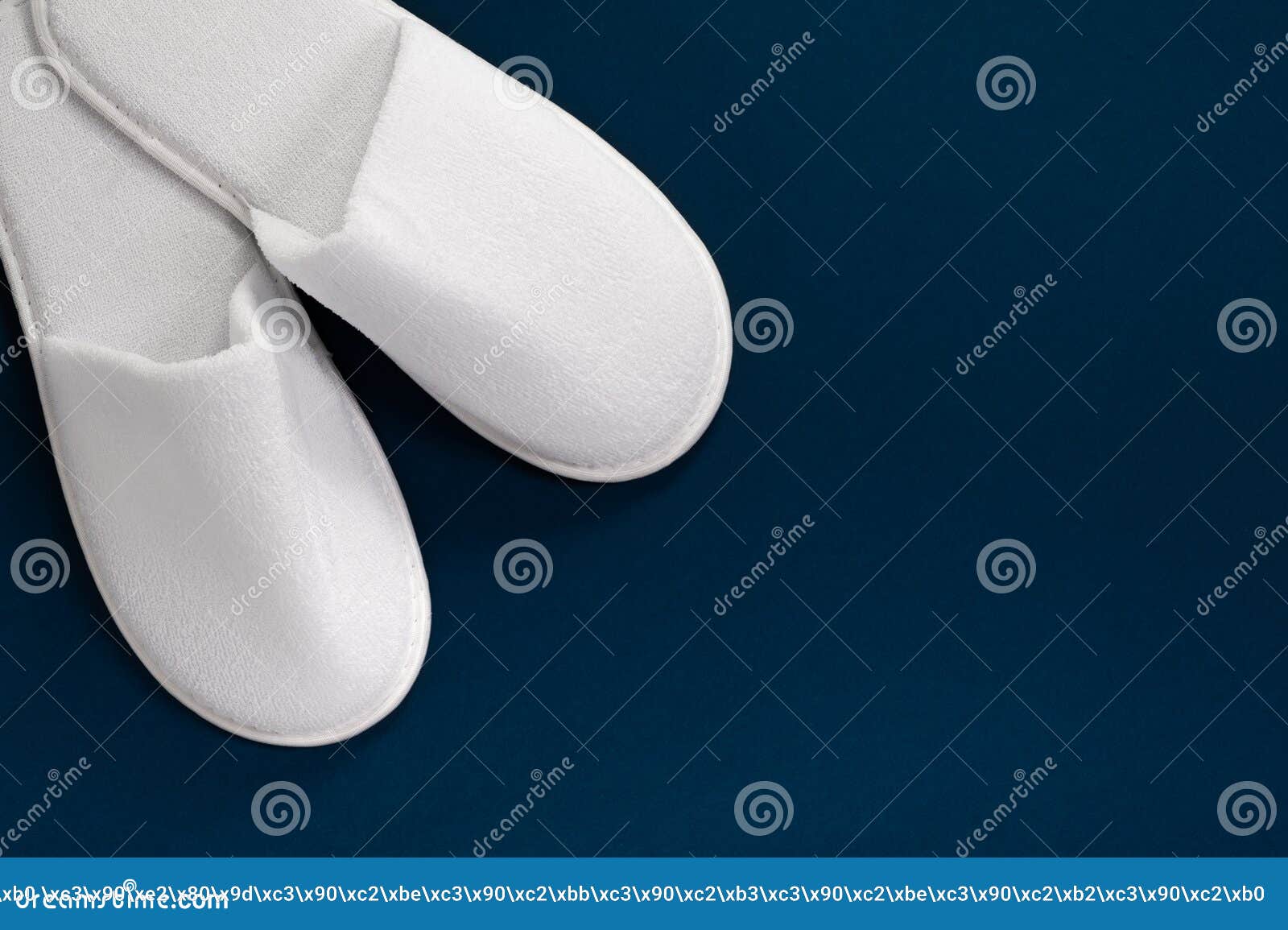 white slippers on a blue background with empty space. slippers for guests. view from above