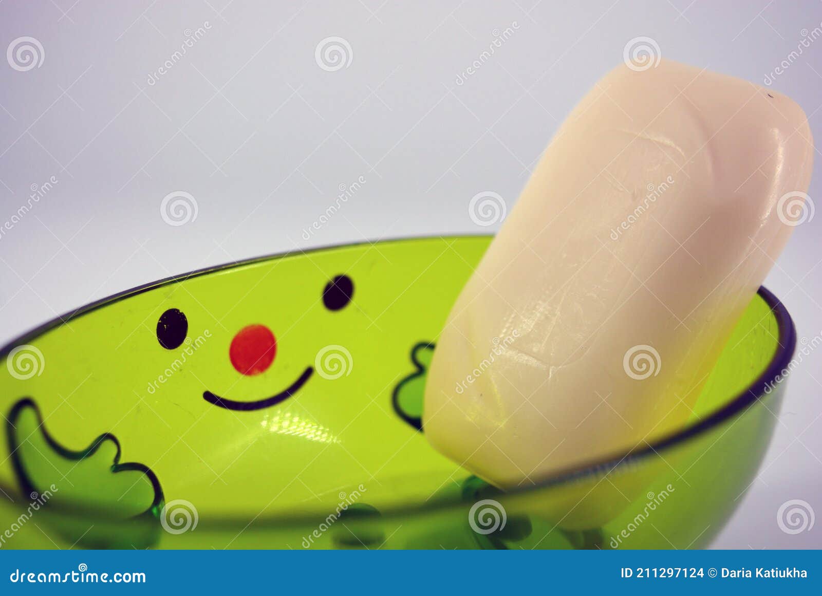 White Soap Lies in a Transparent Green Plastic Soap with Smile. Stock