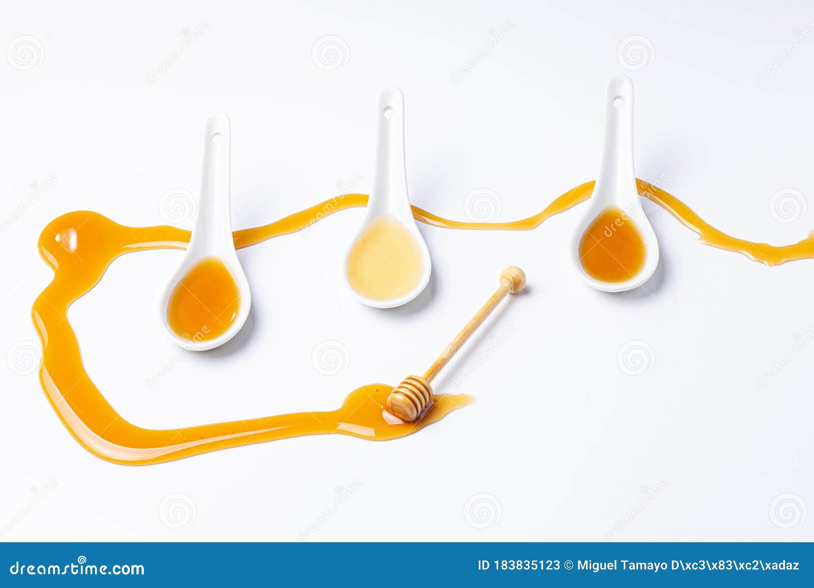 White Spoons And Honey Stick, With Spilled Honey Isolated On White