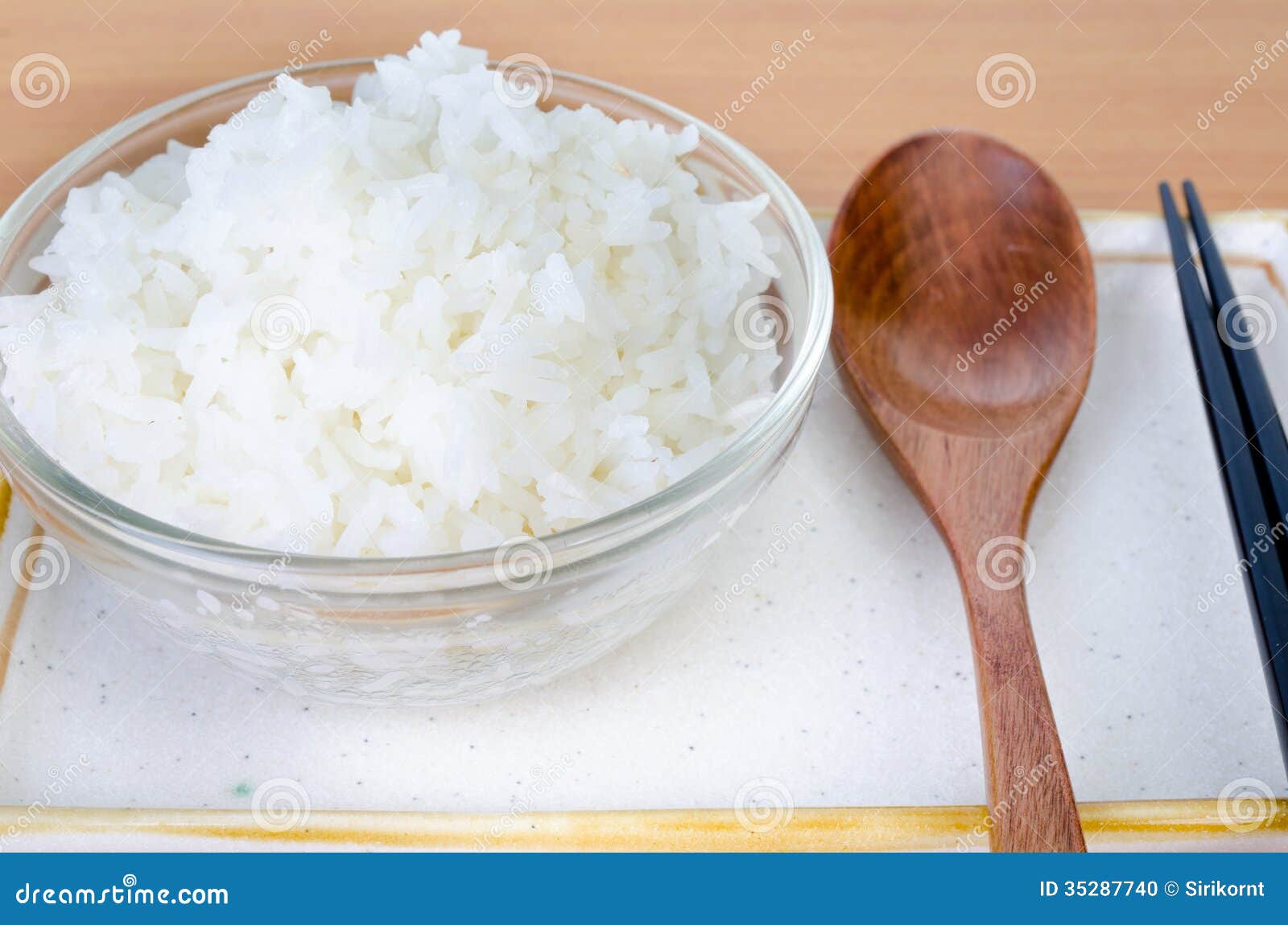 White Steamed Rice in Bowl with Chopsticks and Wood Spoon . Stock Photo