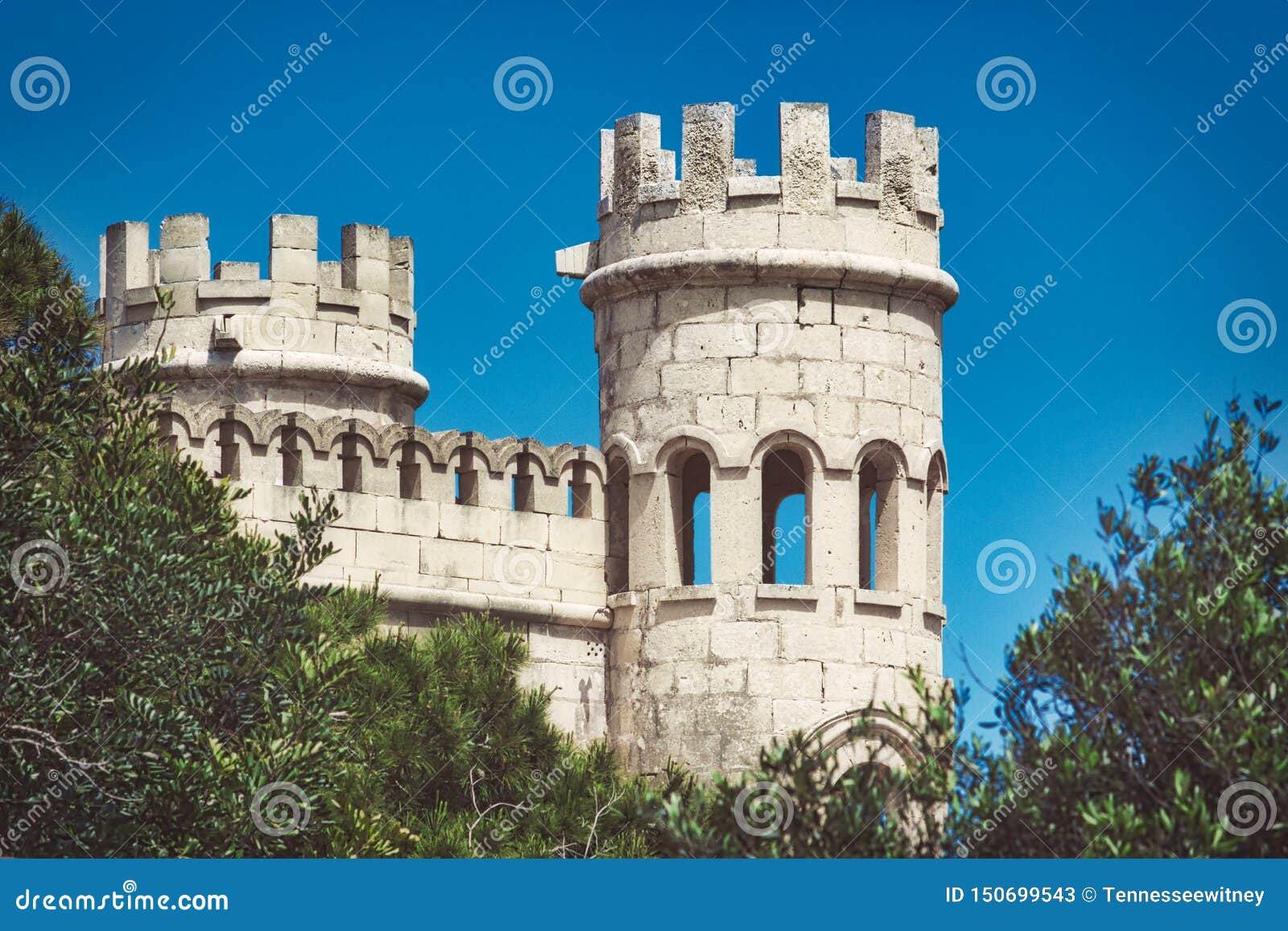 White Stone Turrets of a Medieval Castle Against a Blue Sky Background