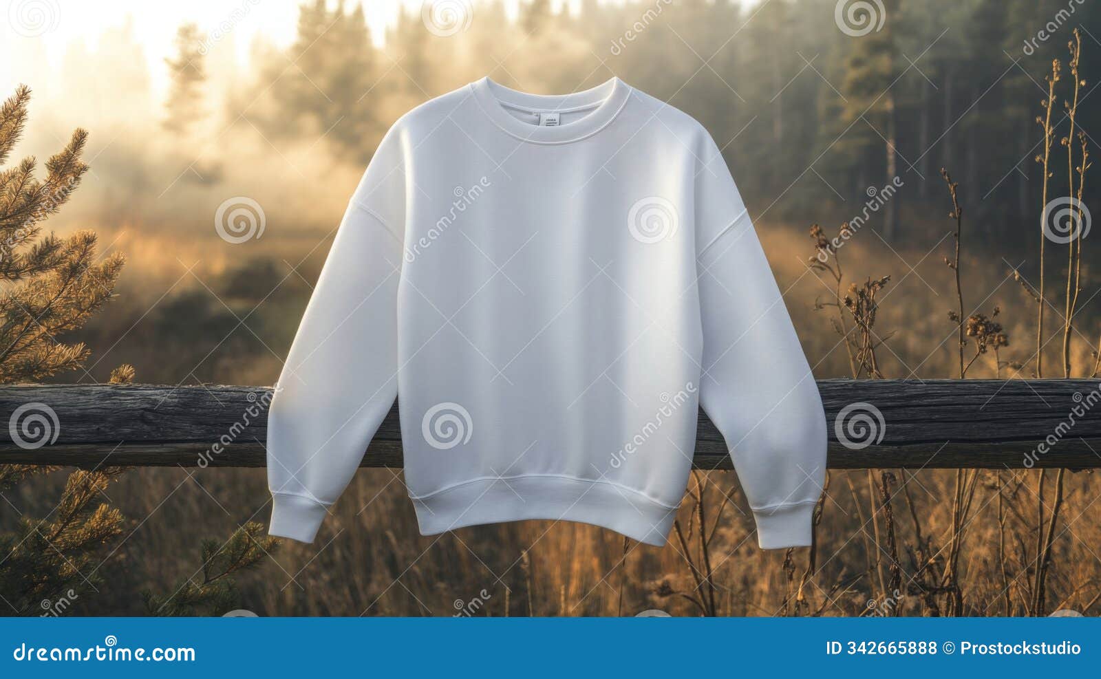 white sweatshirt draped over a wooden fence in a misty forest during early morning light