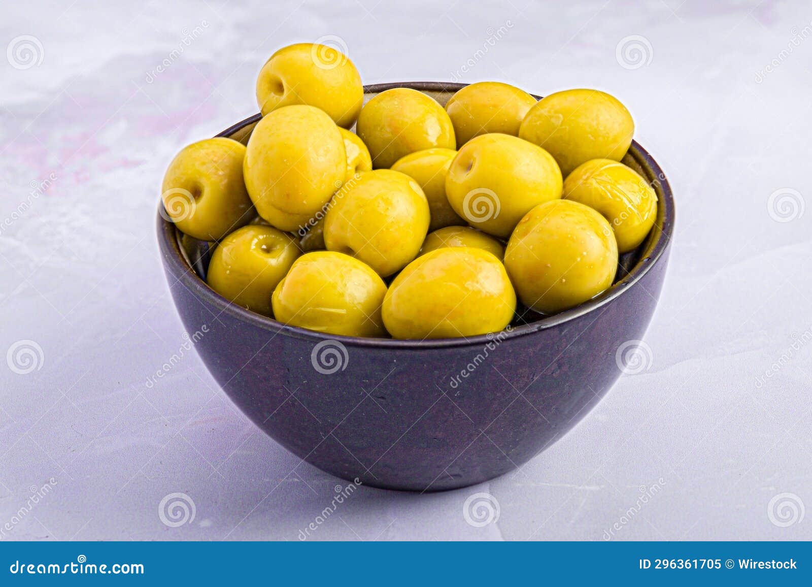white table featuring a bowl filled with bright manzanilla olives