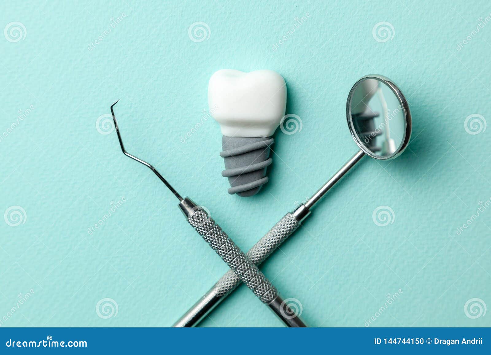 White Teeth Implants on Green Mint Background and Dentist Tools Mirror