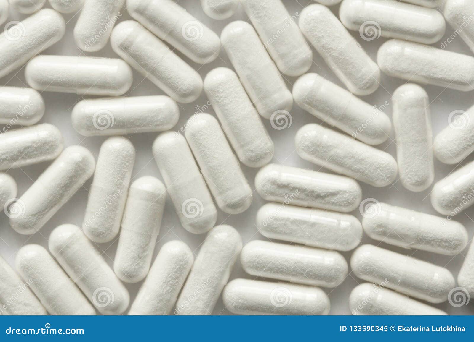 white transparent capsules or tablets on the white background. m