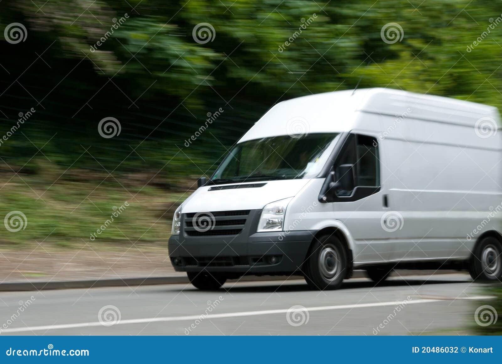 White Van Moving Fast. Witte leveringsbestelwagen met motieonduidelijk beeld op straat met groen/bomen op achtergrond