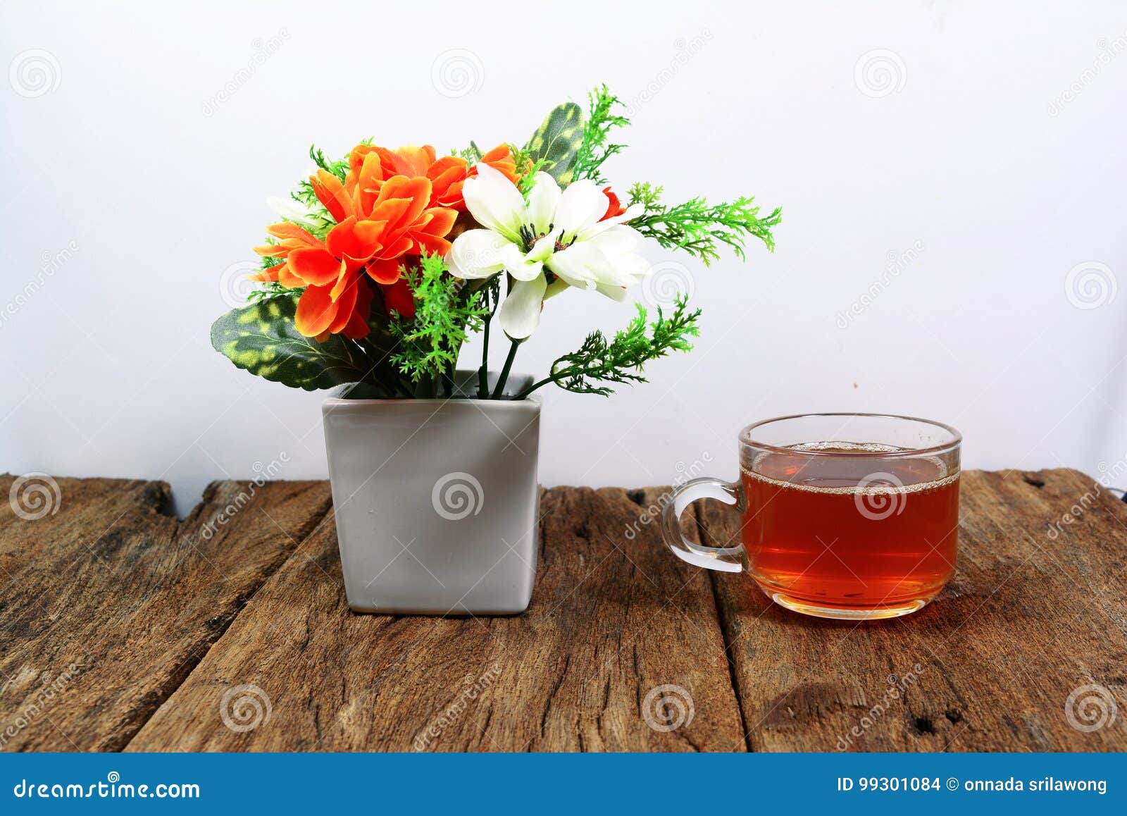 White Vase with Orange White Flowers and a Cup of Tea on W Stock