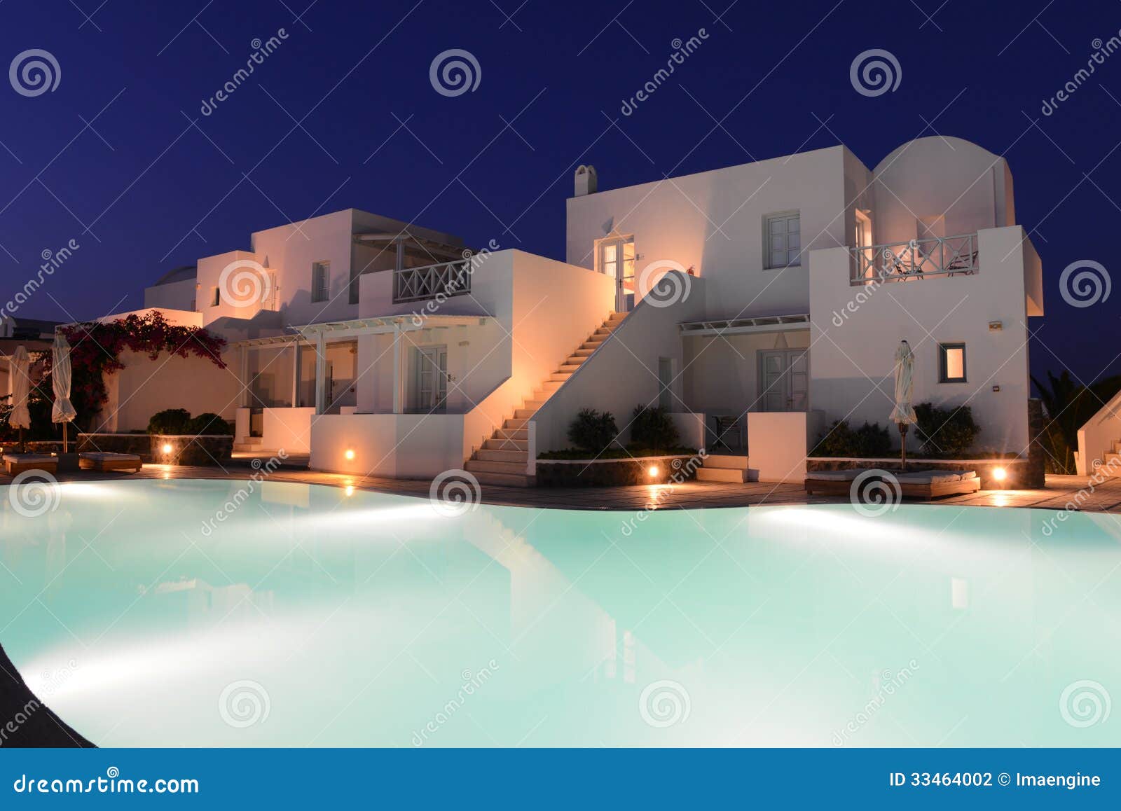 white villas near pool of a luxury resort at night