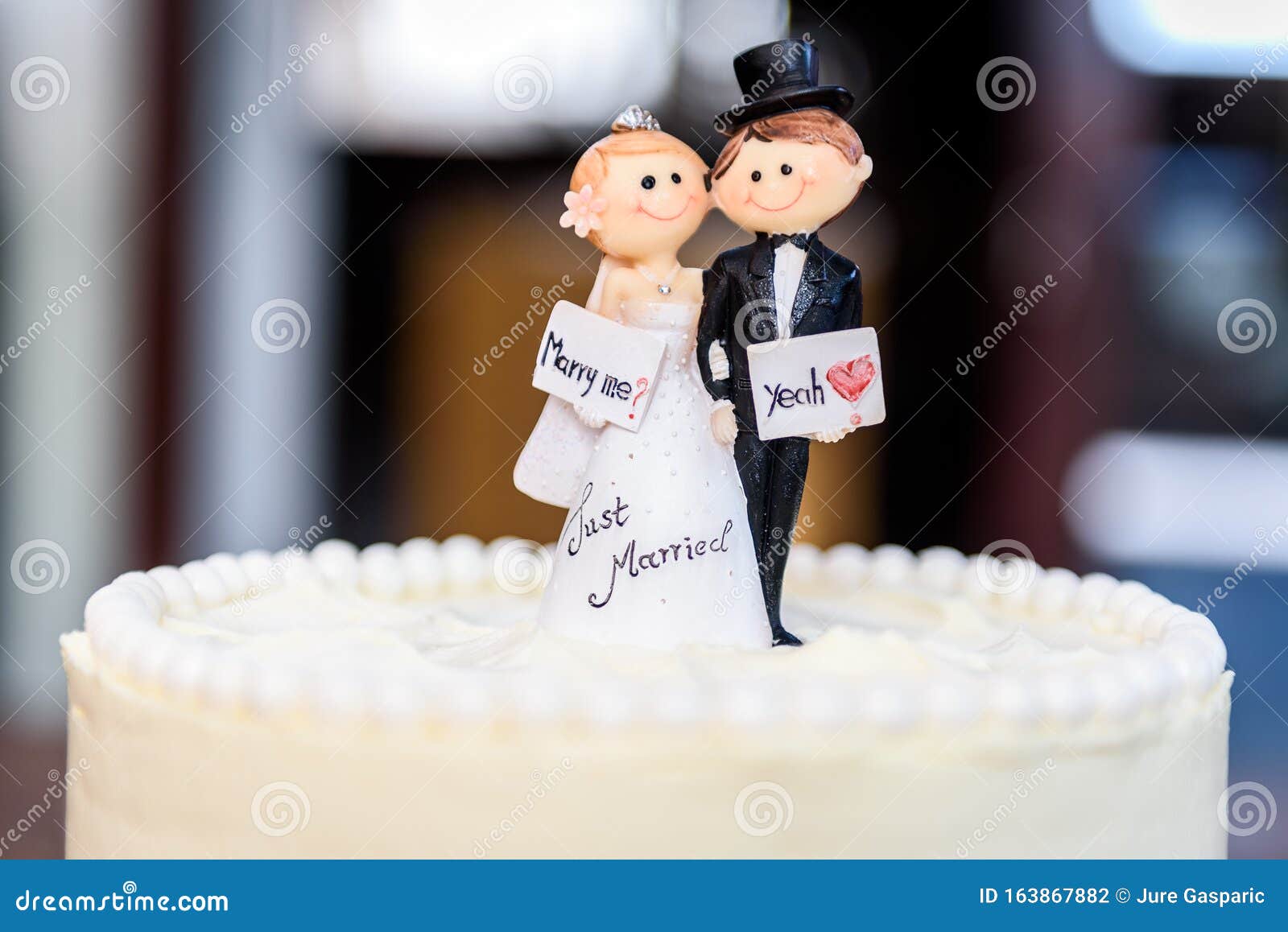 White Wedding Cake with Bride and Groom Figurines on Top Stock ...