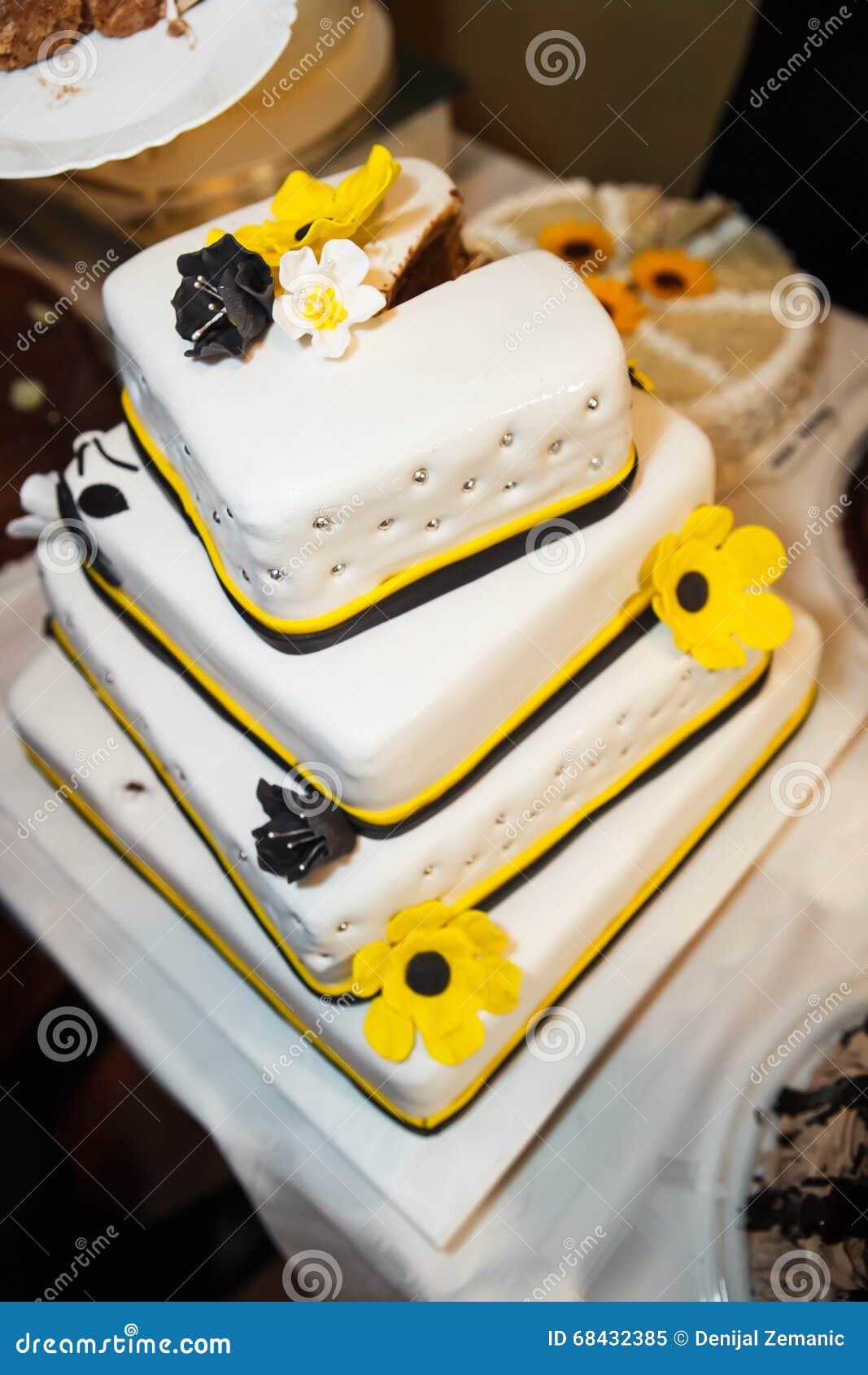 View at the white wedding cake with yellow flowers