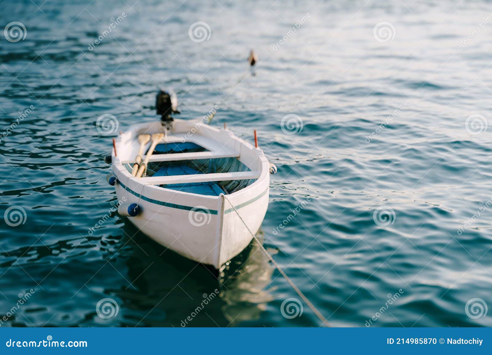 White Wooden Fishing Boat with Oars and Motor. Stock Photo - Image