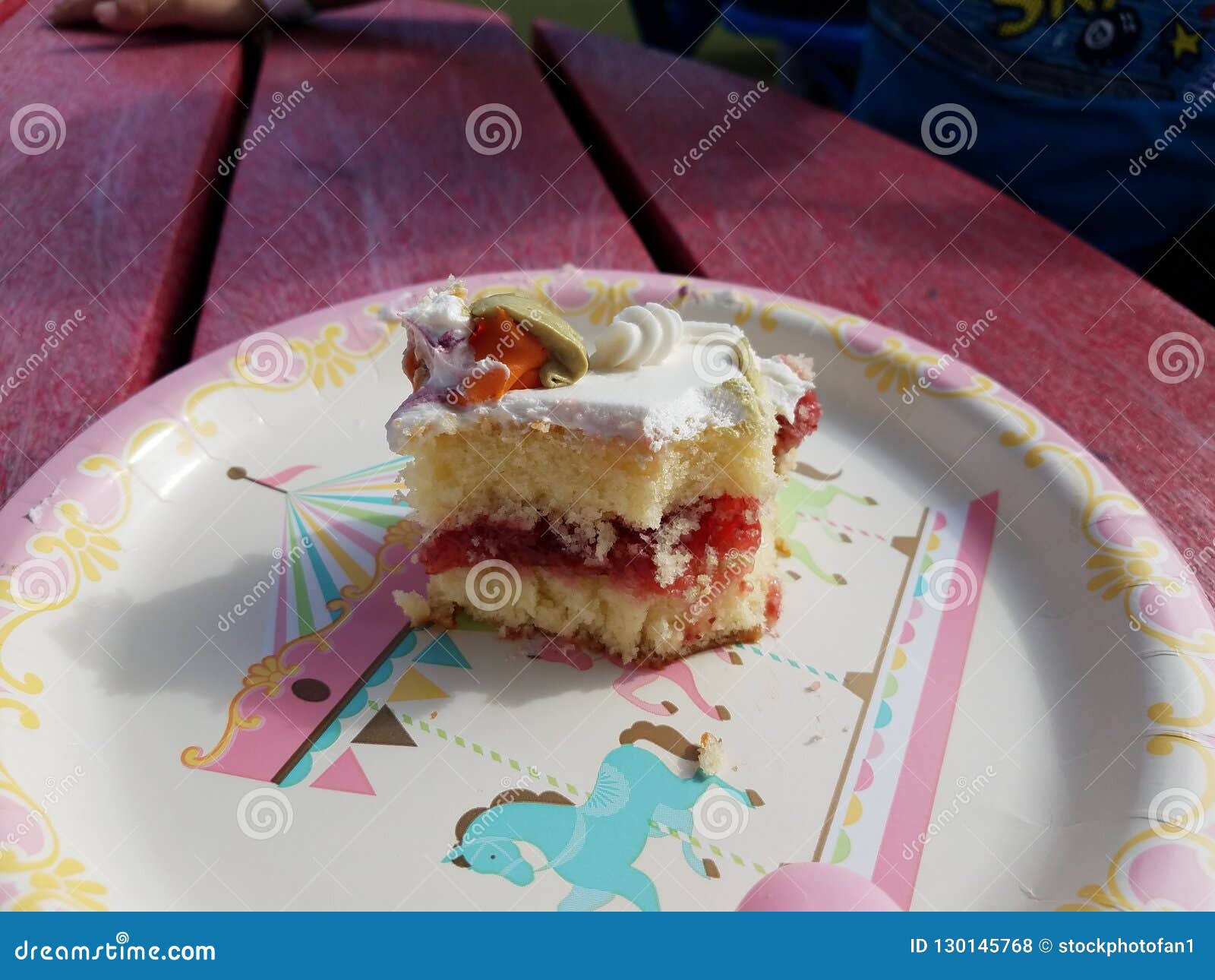 White and Yellow and Red Birthday Cake on Paper Plate Stock Photo