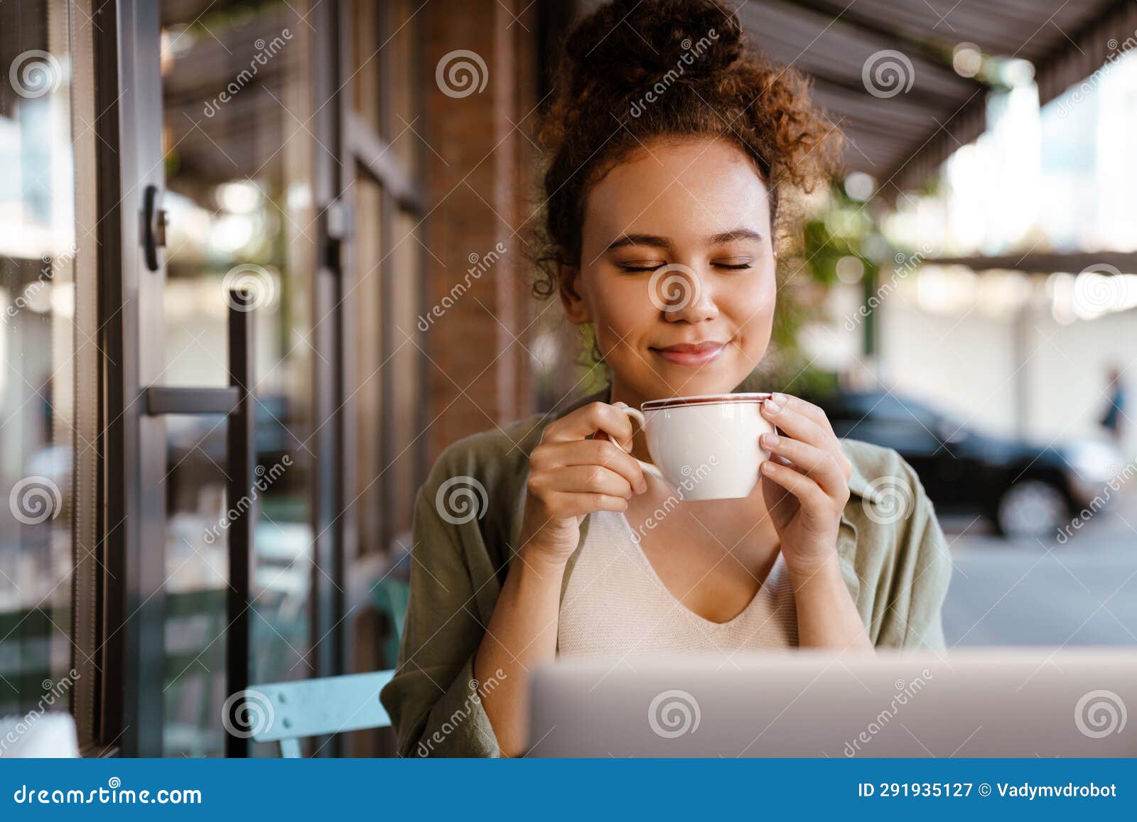 White Woman Smiling and Drinking Coffee while Sitting in Cafe Outdoors ...