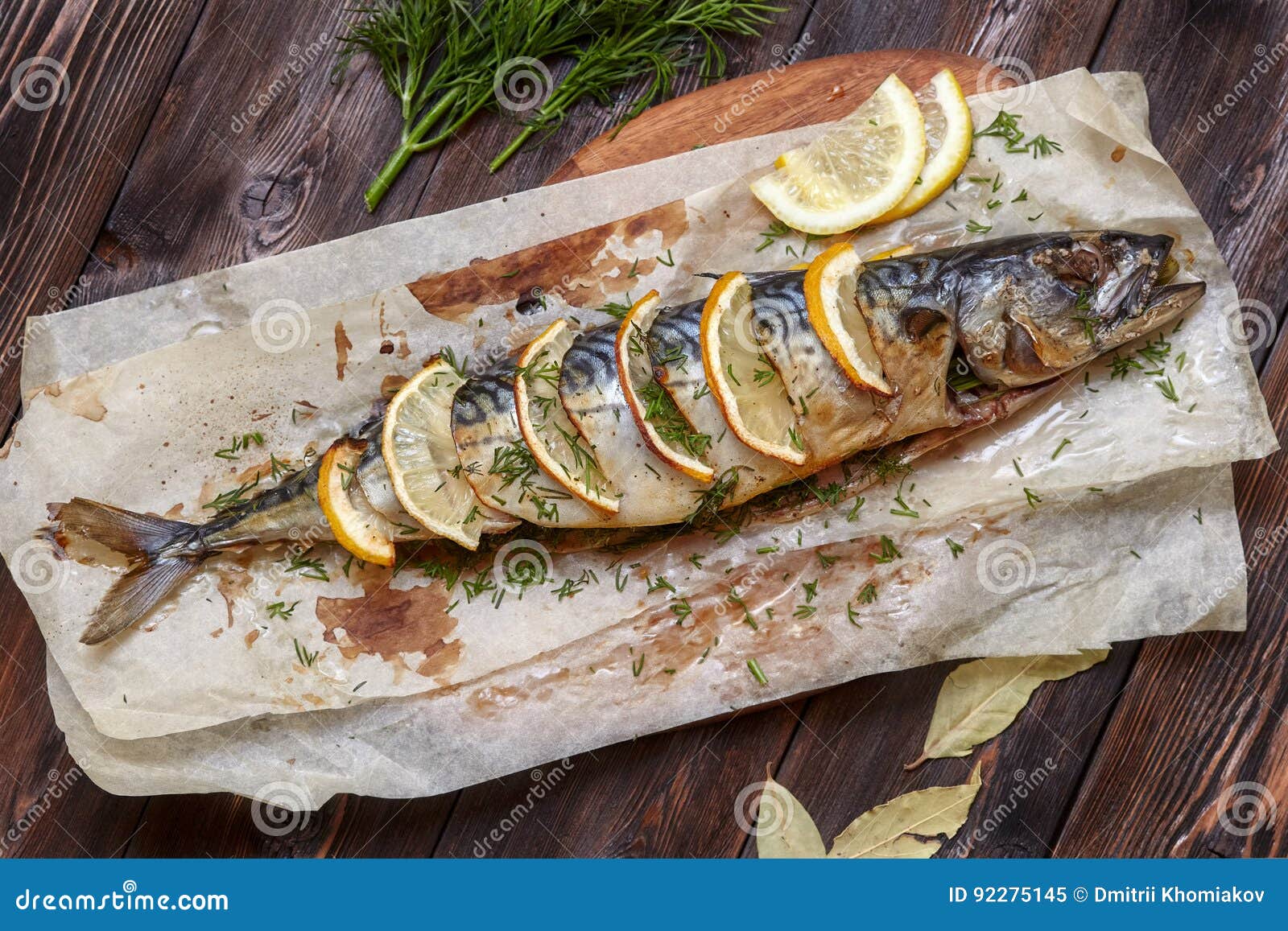 whole baked mackerel or scomber fish with lemon on paper