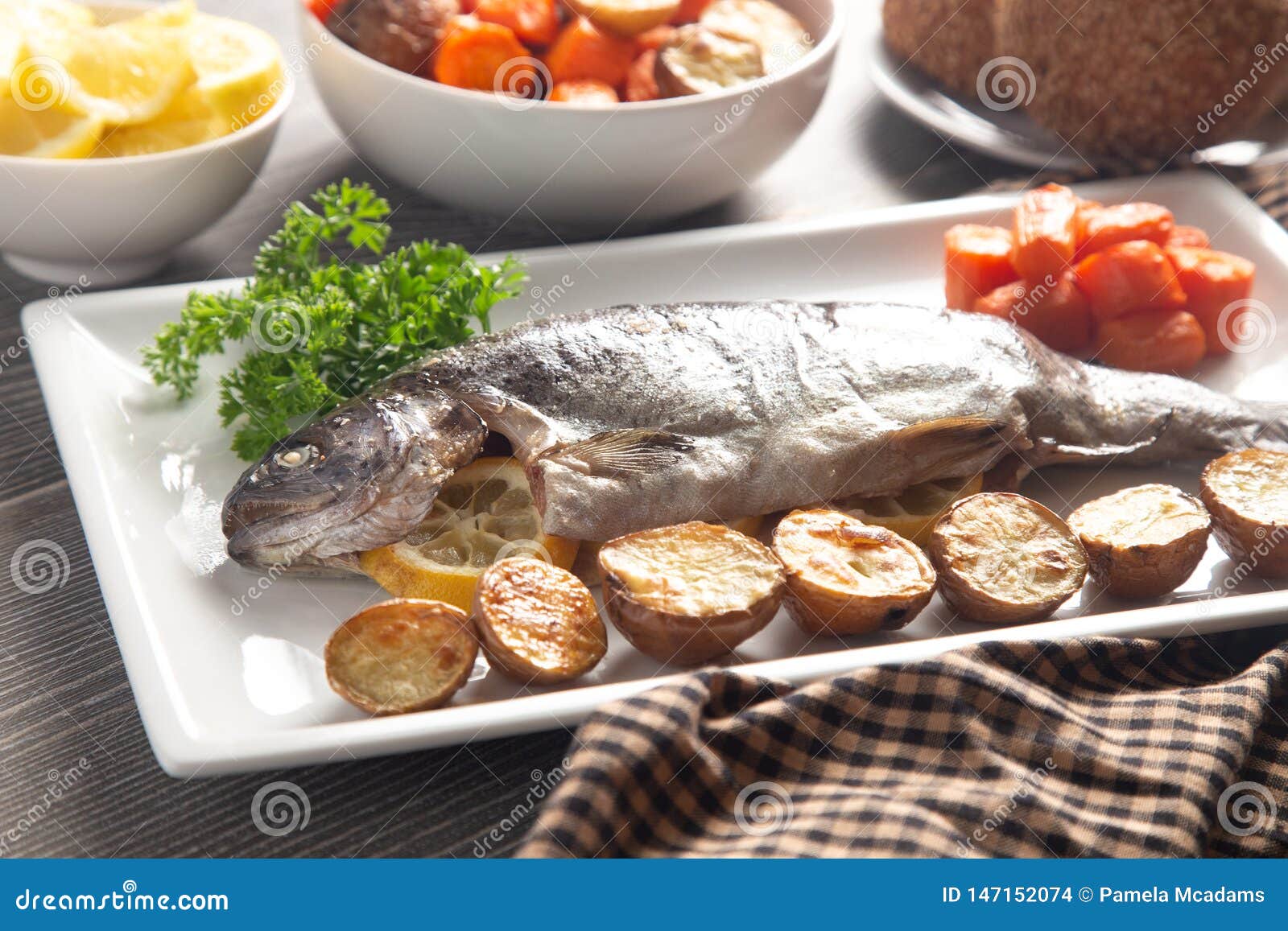 Whole Baked Rainbow Trout on a Table Set for Dinner Stock Photo Image