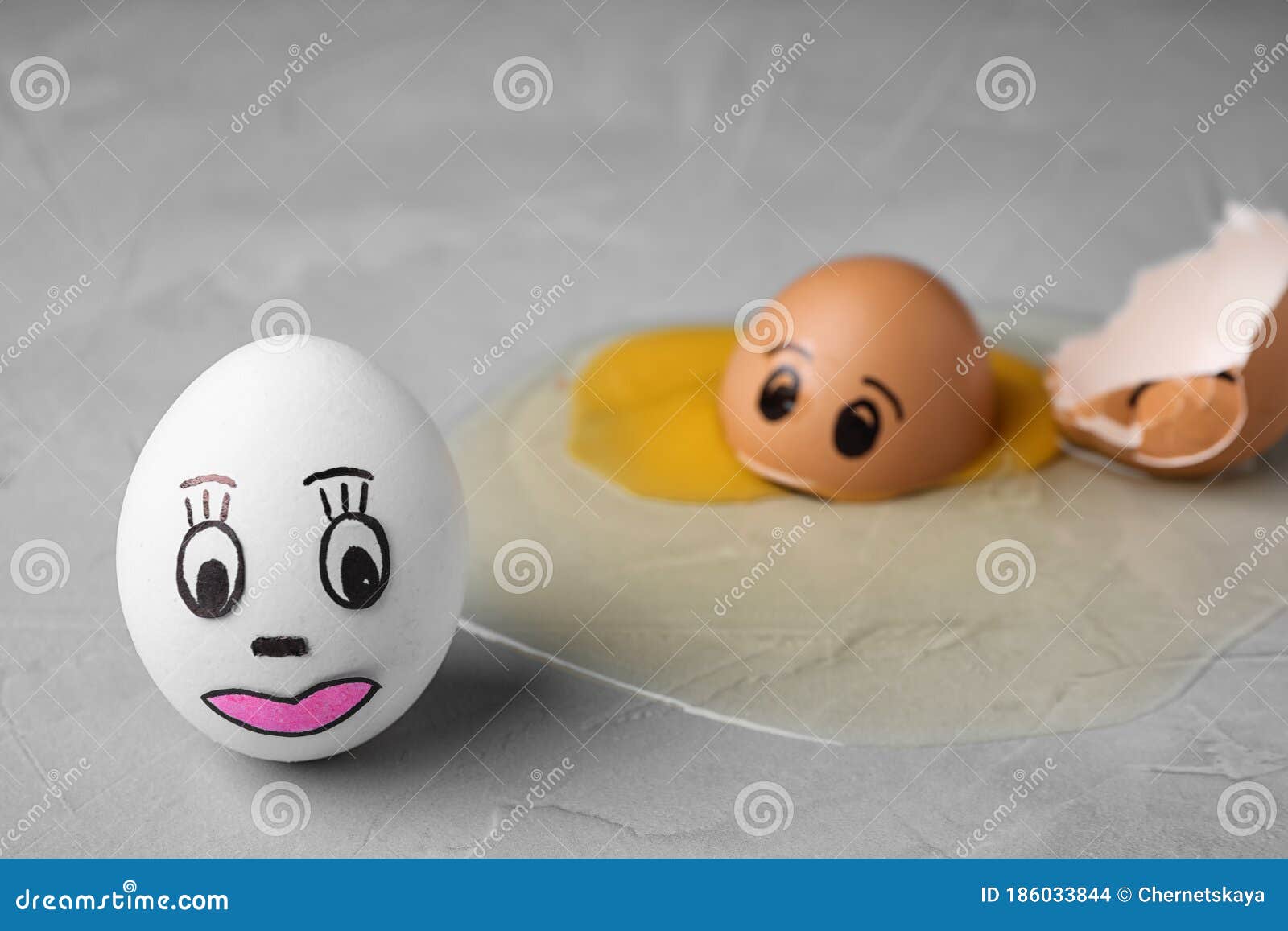 Whole and Broken Eggs with Drawn Faces on Table. Concept of Jealousy