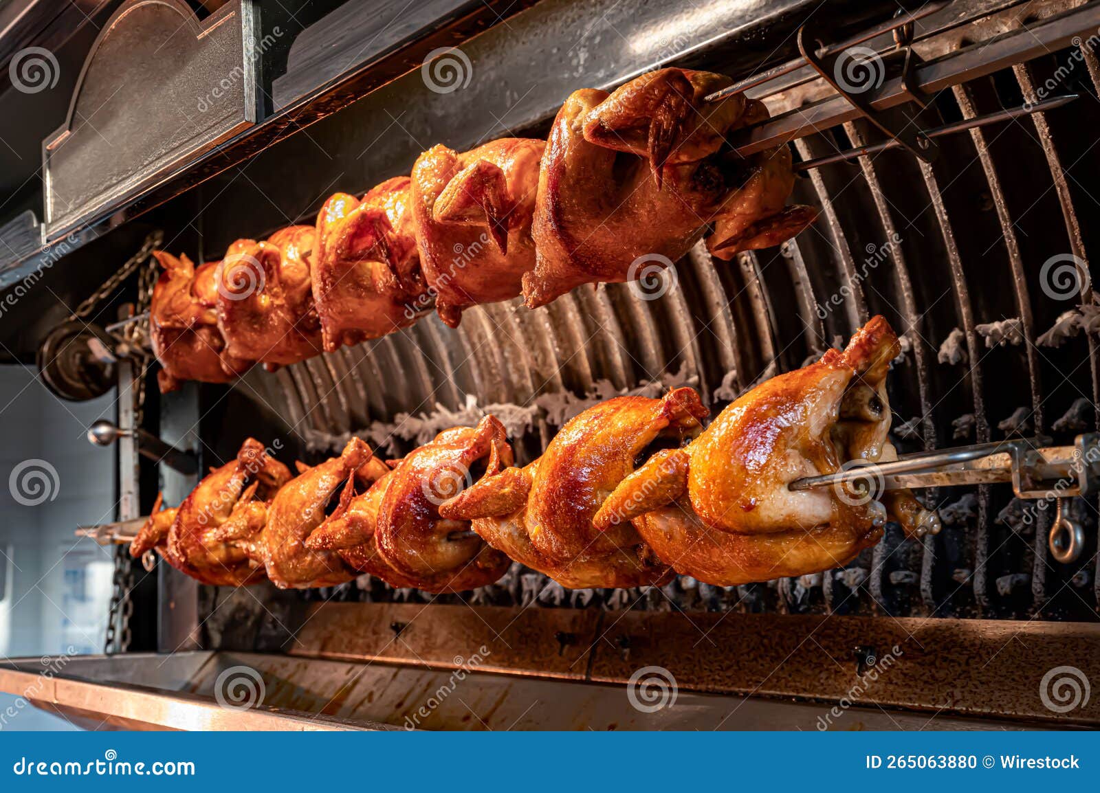Whole Chickens Grilling Process in the Rotisserie Machine Stock Photo