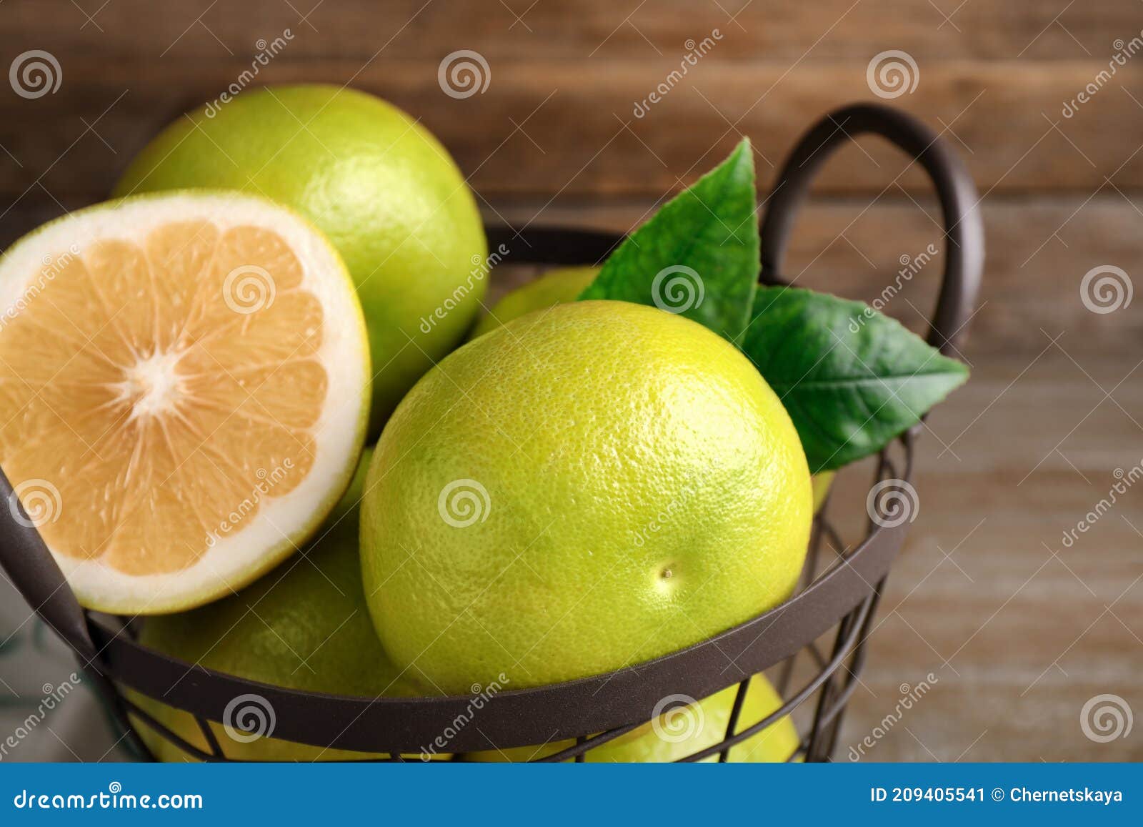 whole and cut sweetie fruits in metal basket, closeup