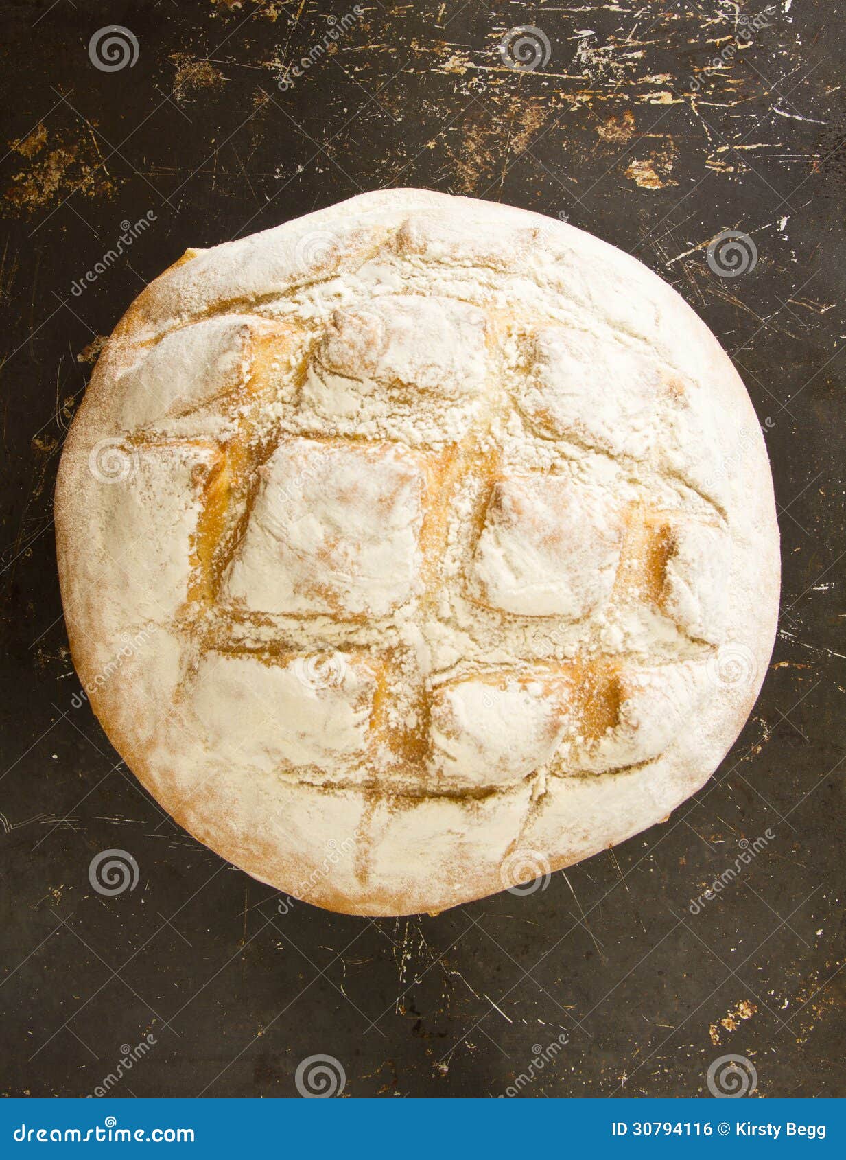a whole english boule bread on distressed baking sheet