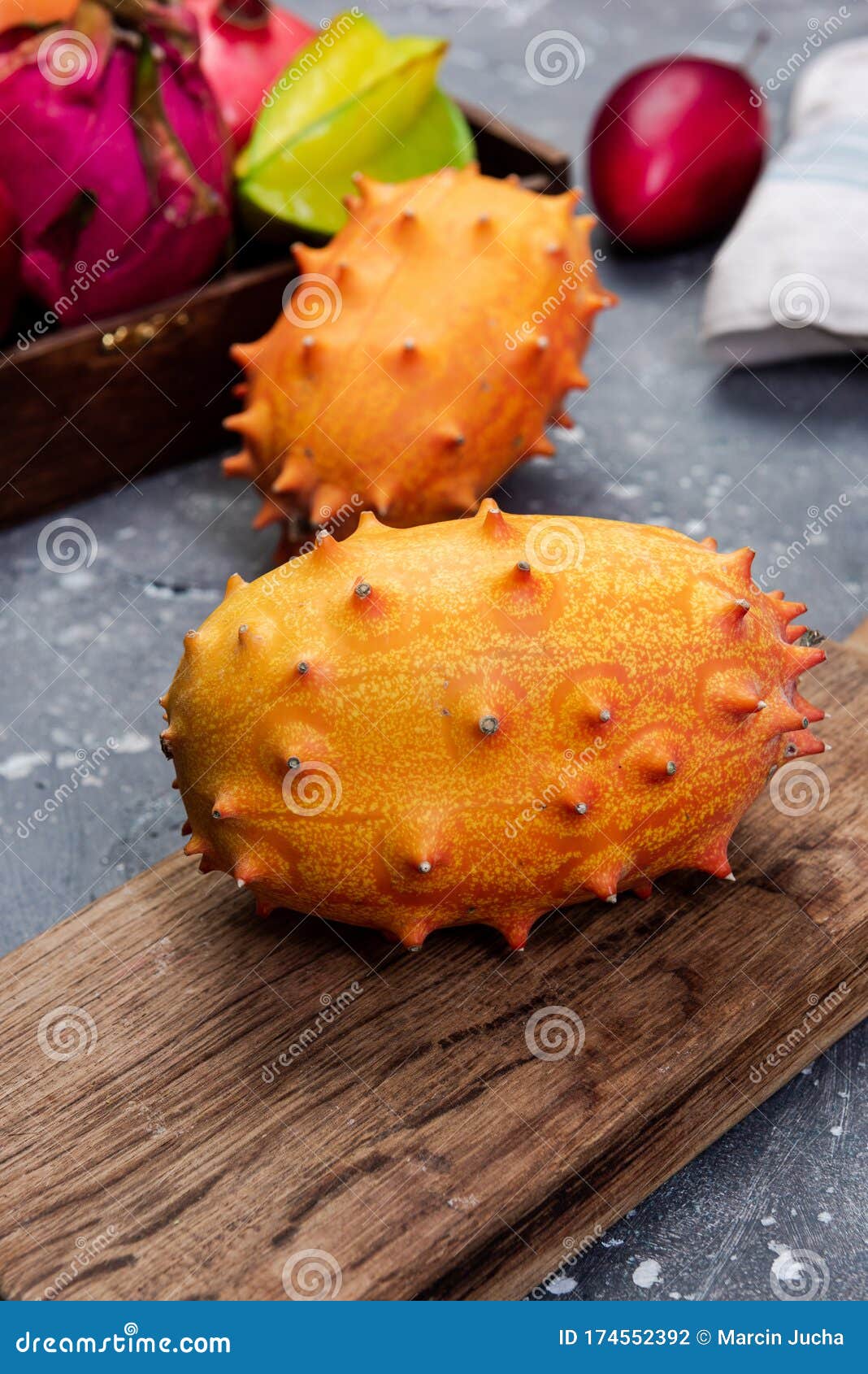 Whole Kiwano or Horned Melon Exotic Fruit on Cutting Board Stock Photo
