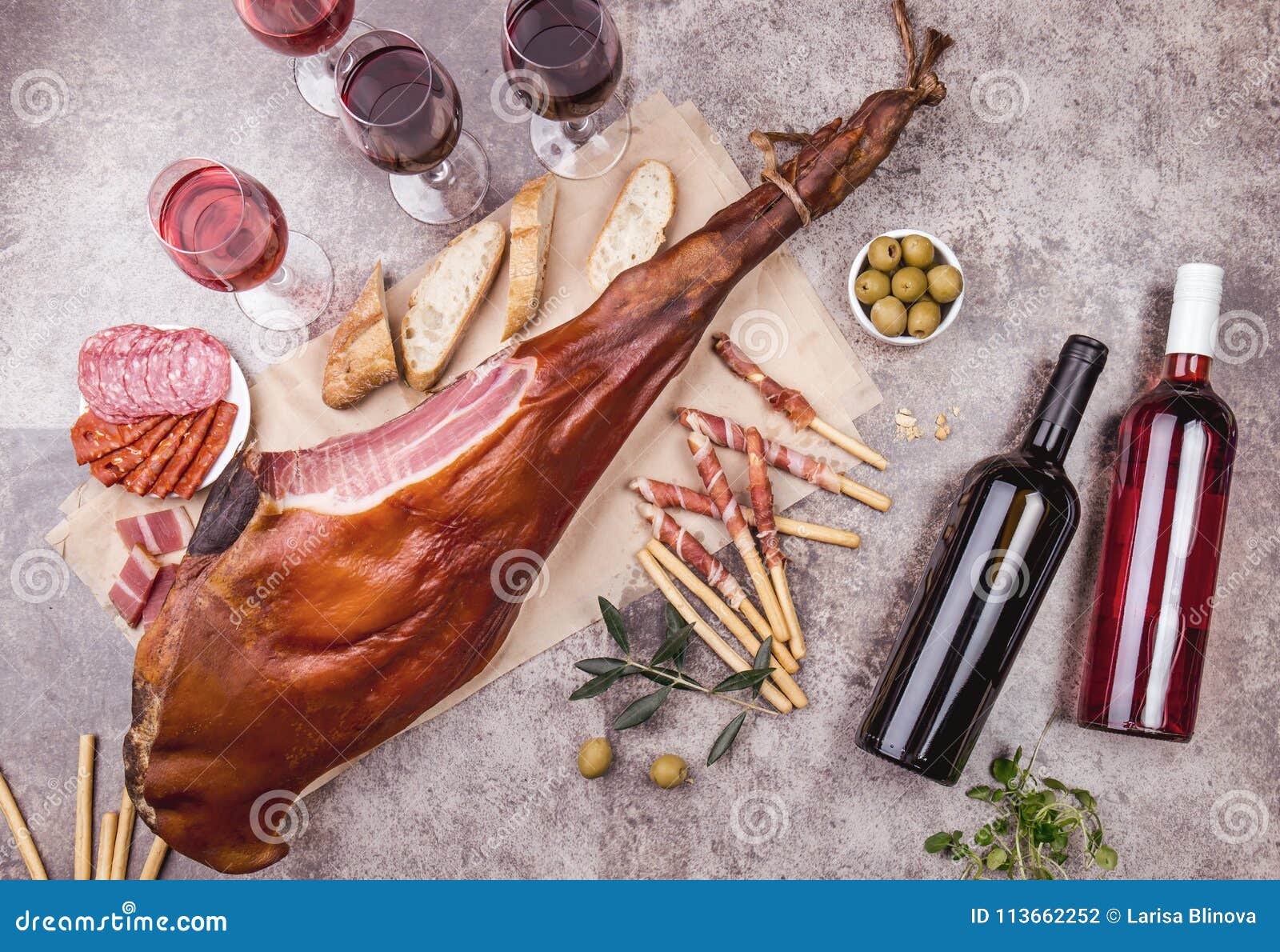 whole leg ham jamon serrano and red and rose wine on gray background. top view. flat lay