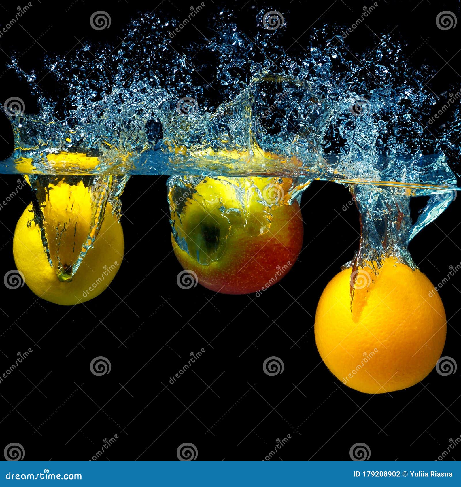 Whole Orange, Lemon and Apple in Water on a Black Background. Fresh