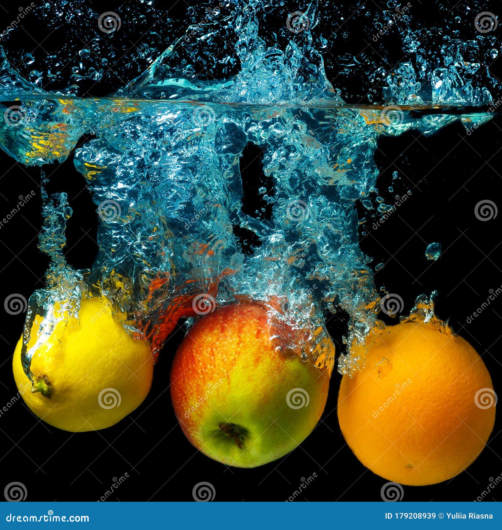 Whole Orange, Lemon and Apple in Water on a Black Background. Fresh