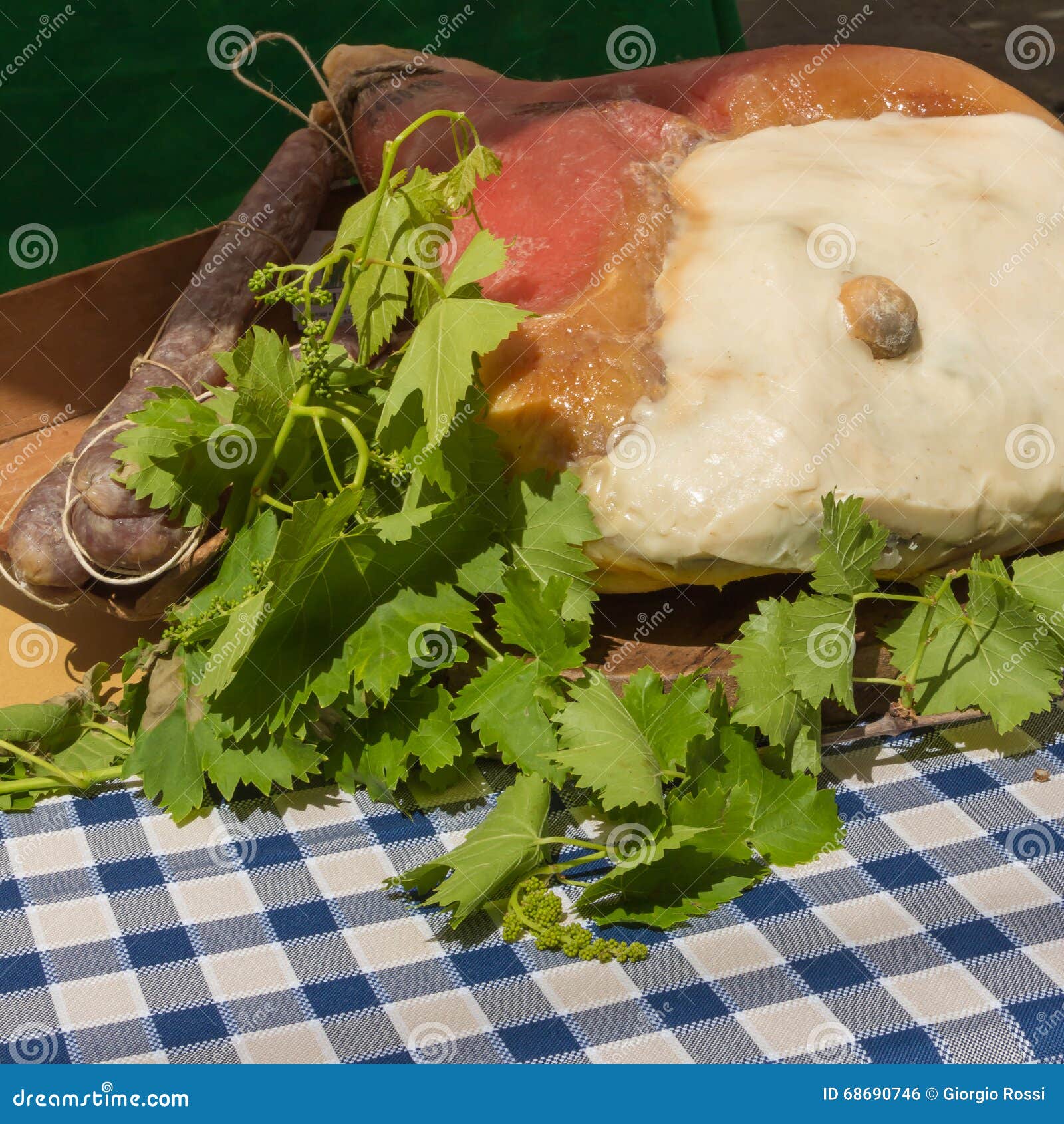 Whole Parma Raw Ham Leg, Sausage and Maple Leafs on Table Stock Photo