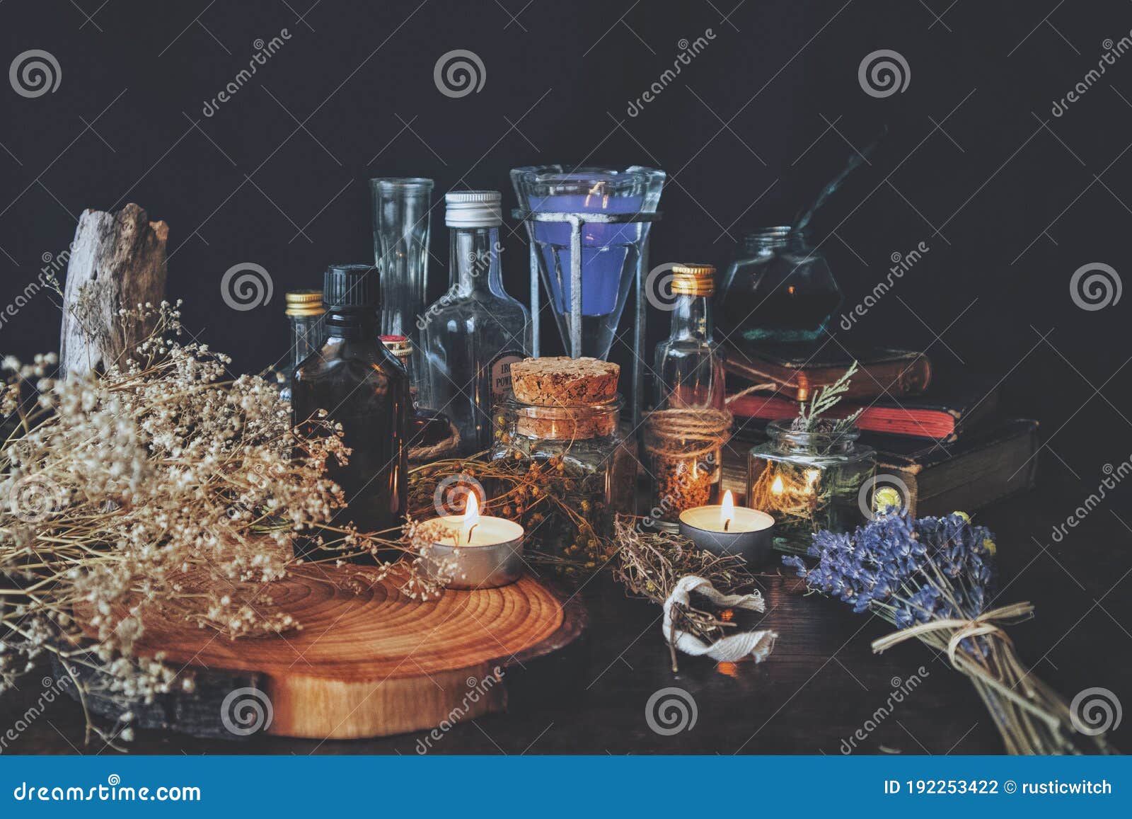 wiccan witch apothecary - various ingredients, potions and dried herb bottles and jars for magick, placed on an altar.