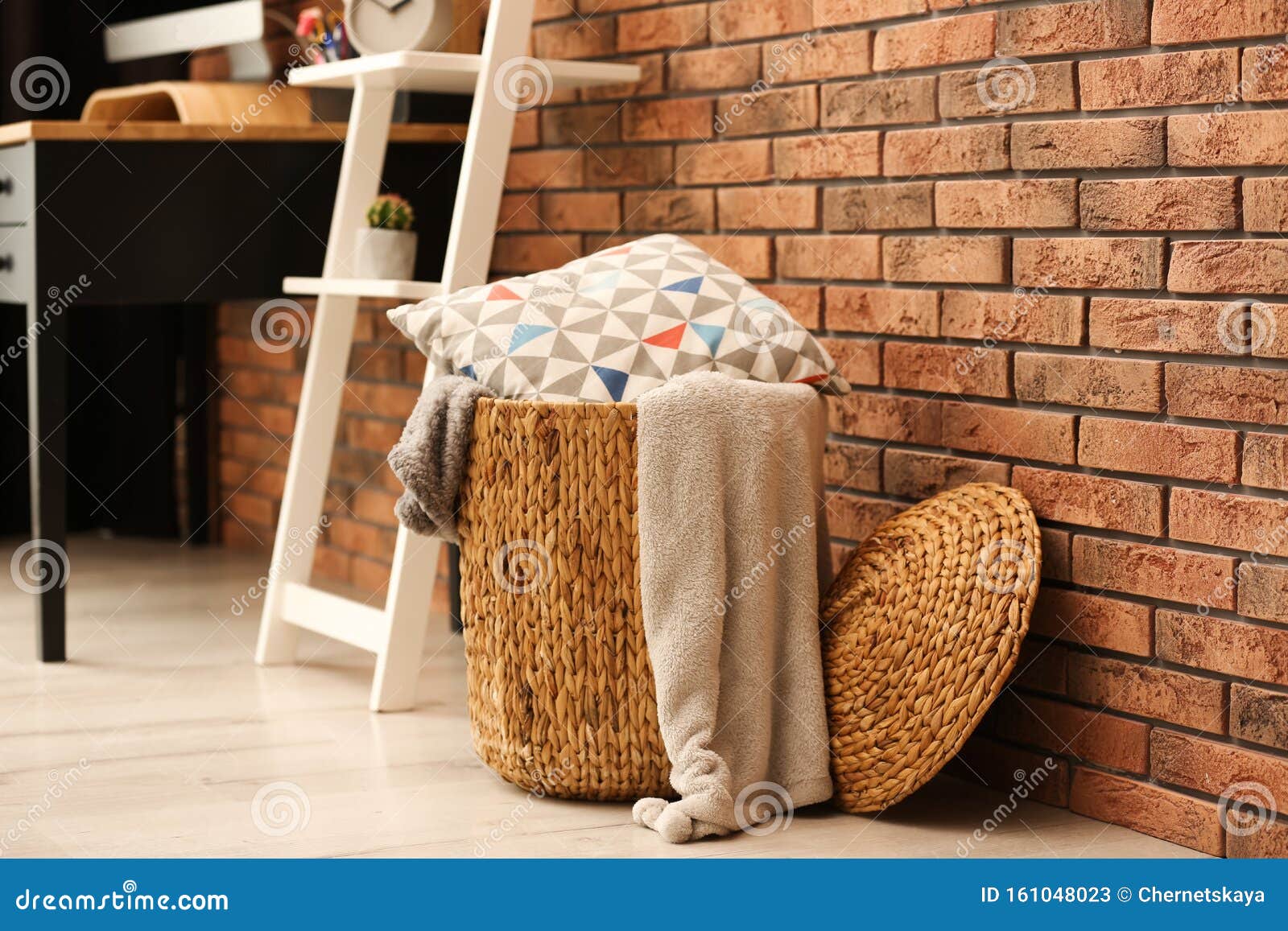 Wicker Basket with Blankets and Pillow Near Wall, Space for Text. Idea