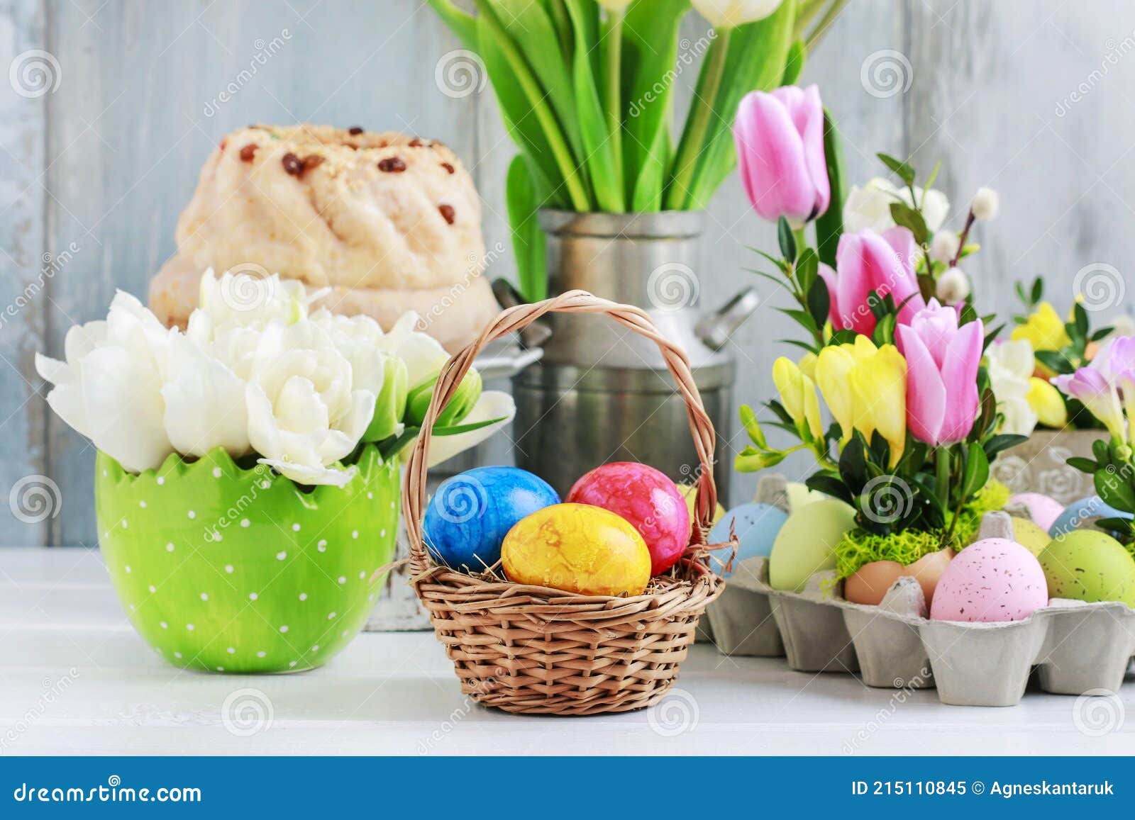 Wicker Basket with Easter Eggs on the Table. Floral Decorations in the ...