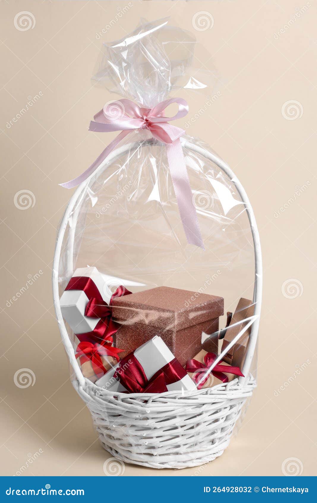 Wicker Basket Full of Gift Boxes on Beige Background Stock Photo