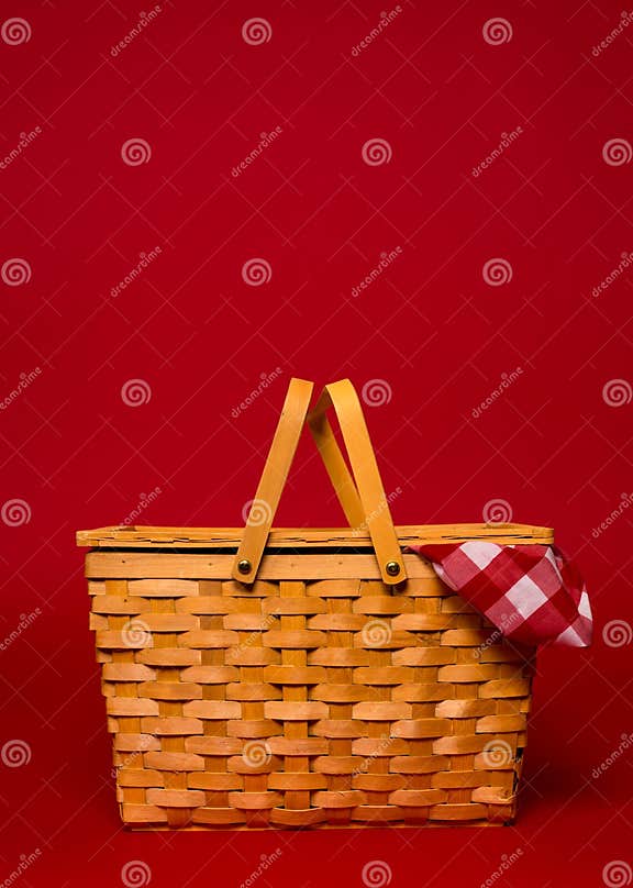 A Wicker Picnic Basket with Red Gingham Tablecloth on a Red Back Stock