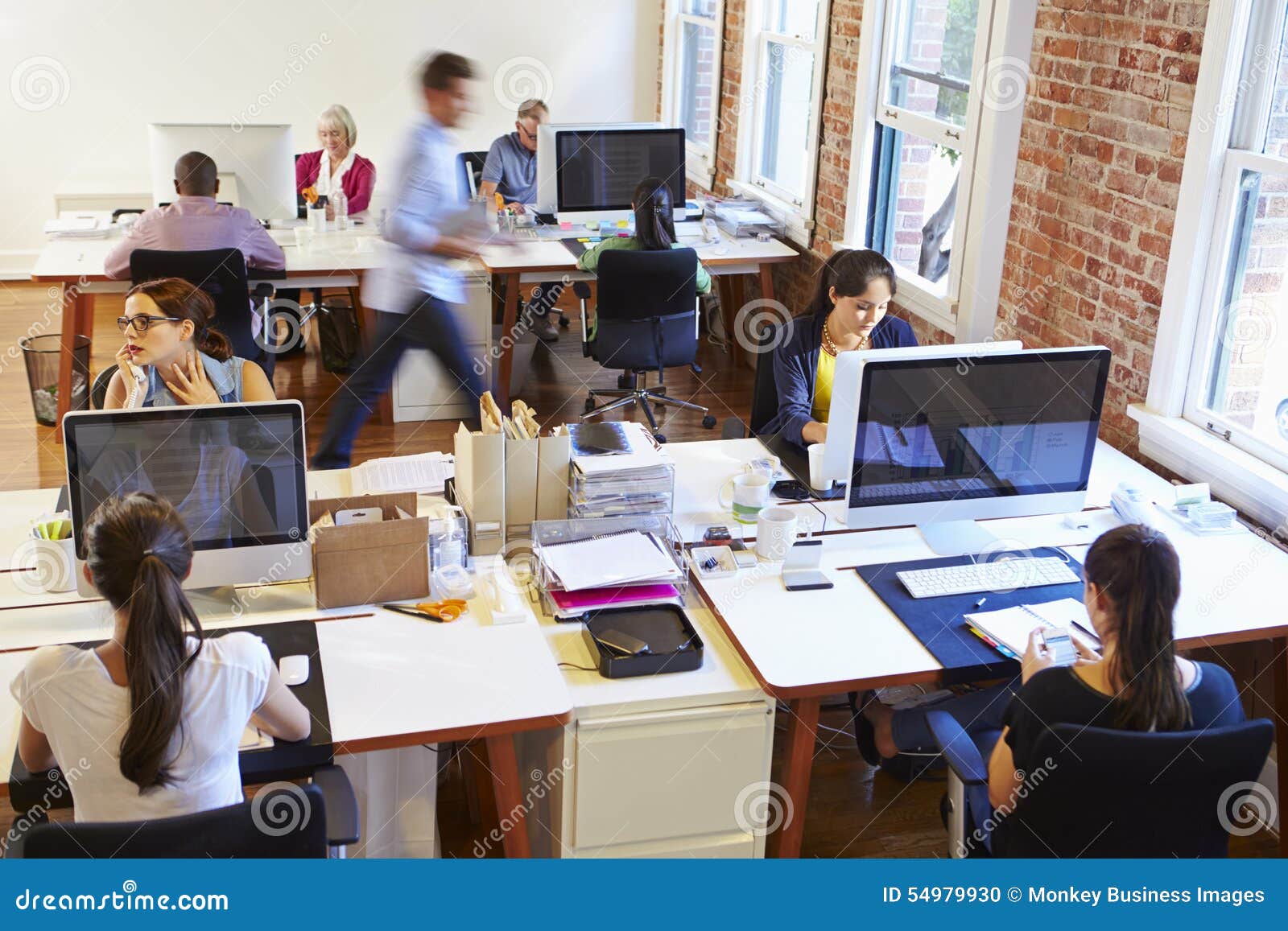 wide angle view of busy  office with workers at desks