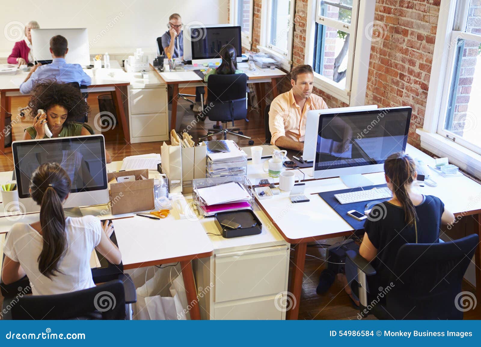 Wide Angle View of Busy Design Office with Workers at Desks Stock Photo