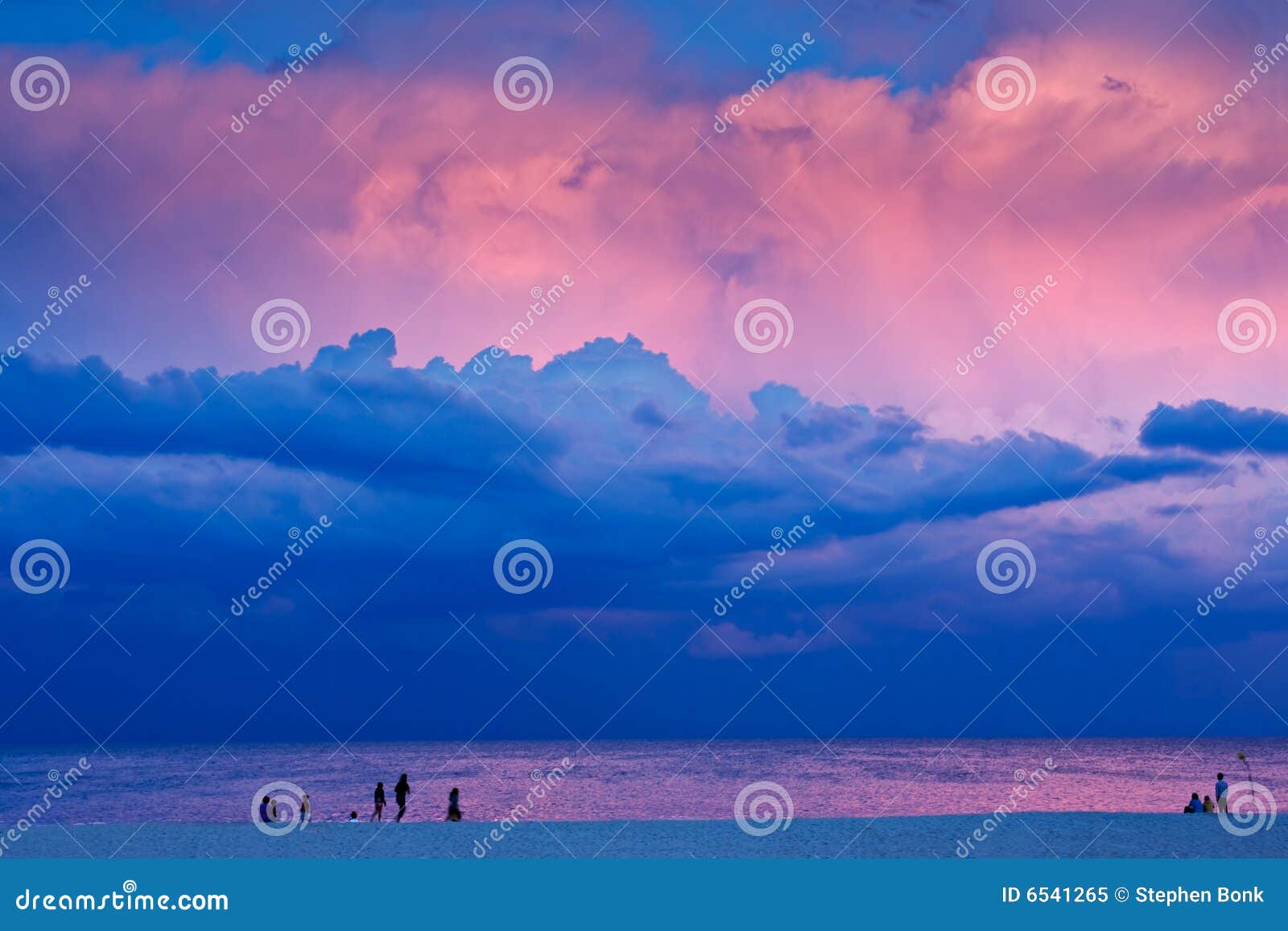 Wieczór plażowa scena. Plaży chmur dramatycznego wieczór kopyto szewskie oświetleniowi zasięrzutni ludzie promieni sceny nieba tam  światło słoneczne niektóre burzowy zmierzch