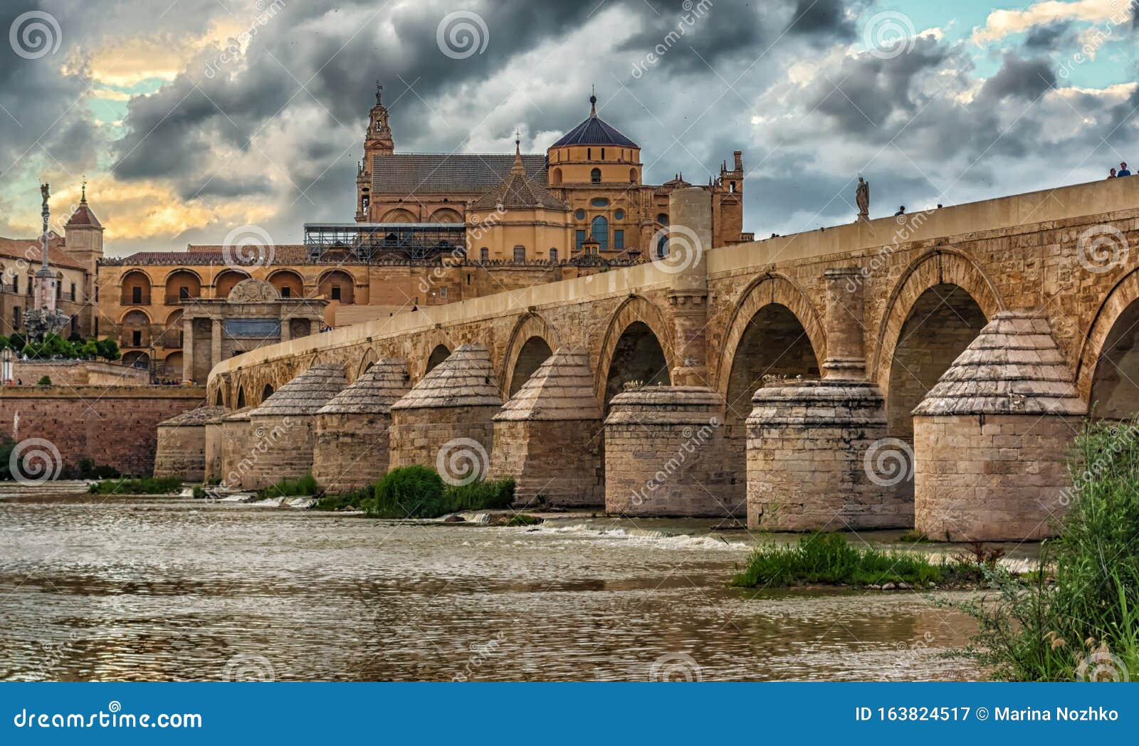 wiew of the roman bridge puente romano and umayyad mosque mezquita-cathedral in the evening, cordoba, spain