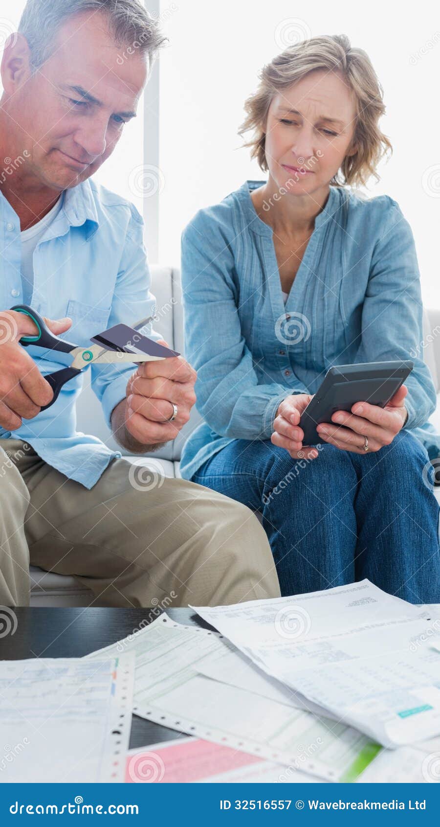Wife Watching Her Husband Cut Credit Card in Half Stock Im