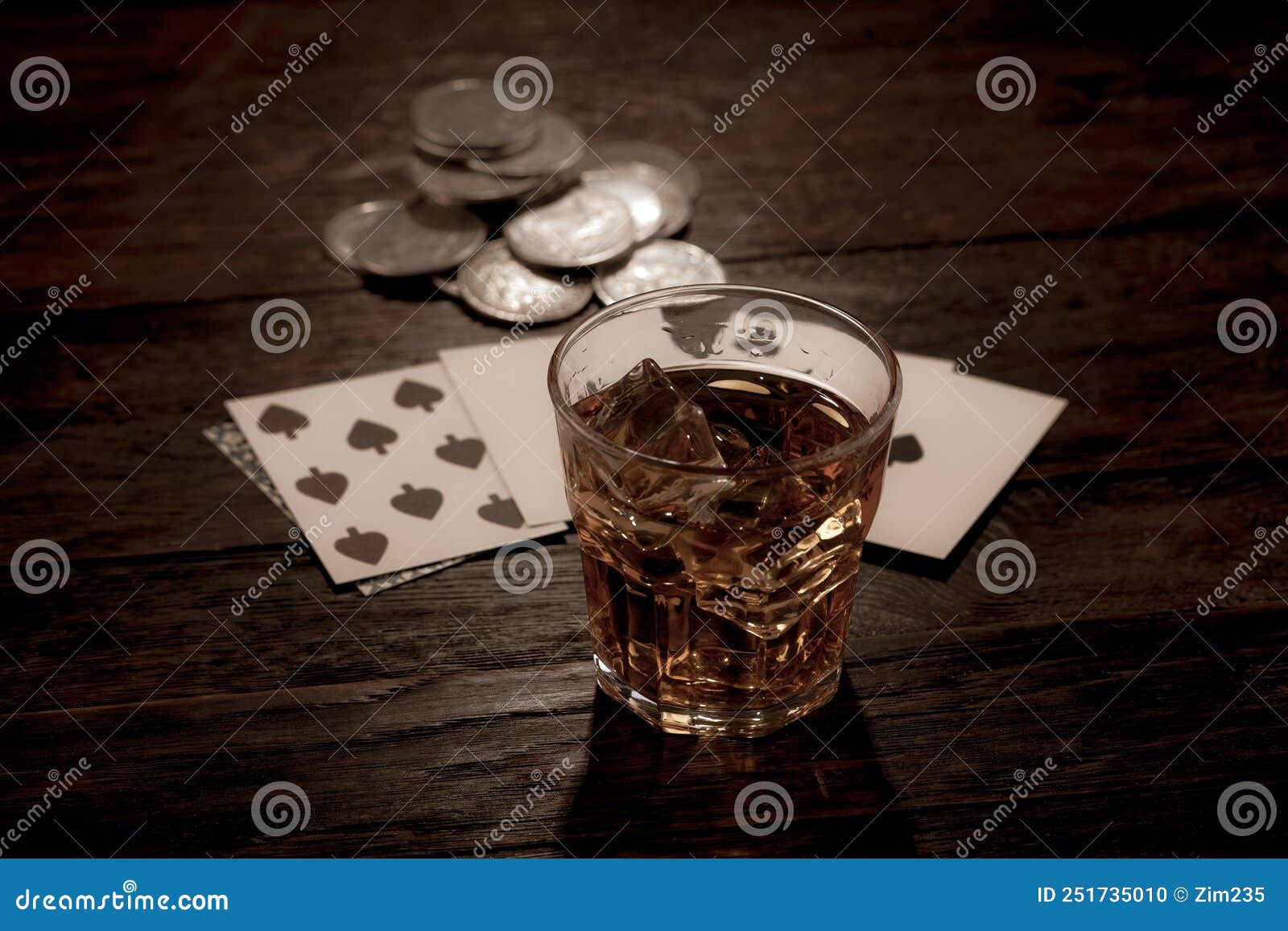 wild west gambling. dead man`s hand, silver coins and whiskey shot. two-pair poker hand consisting of the black aces and black