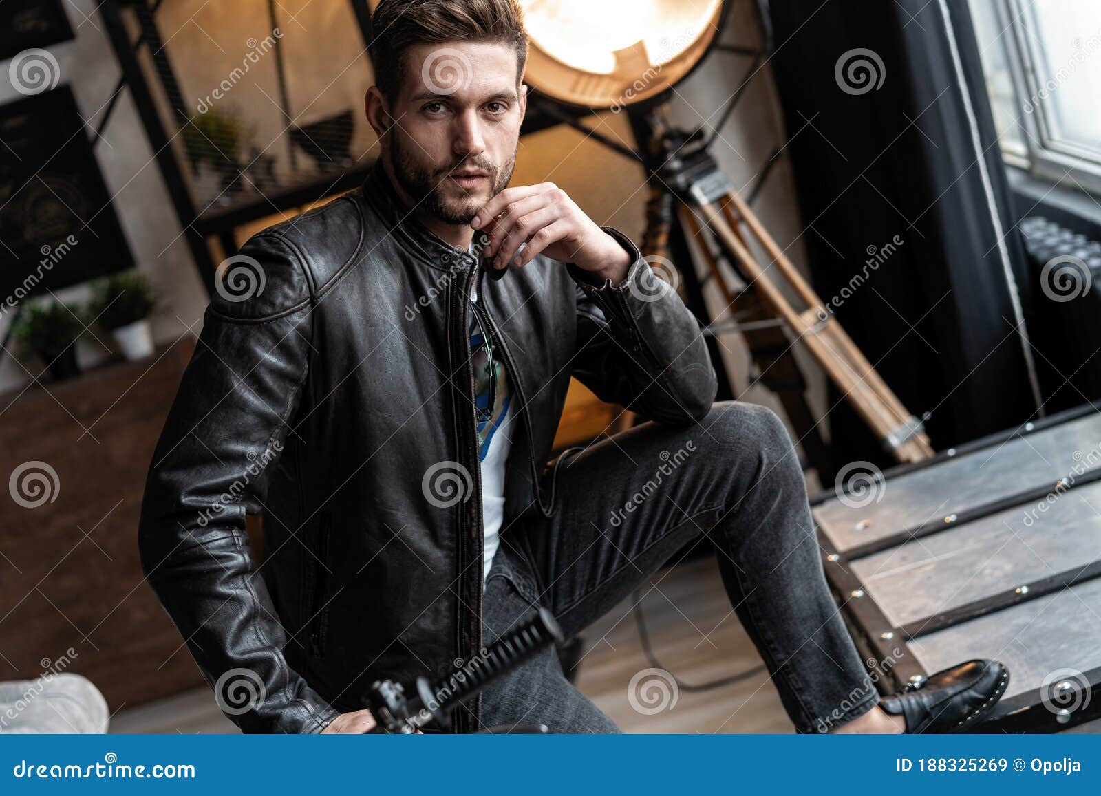 Handsome Young Man in Leather Jacket Looking Away while Sitting on the ...