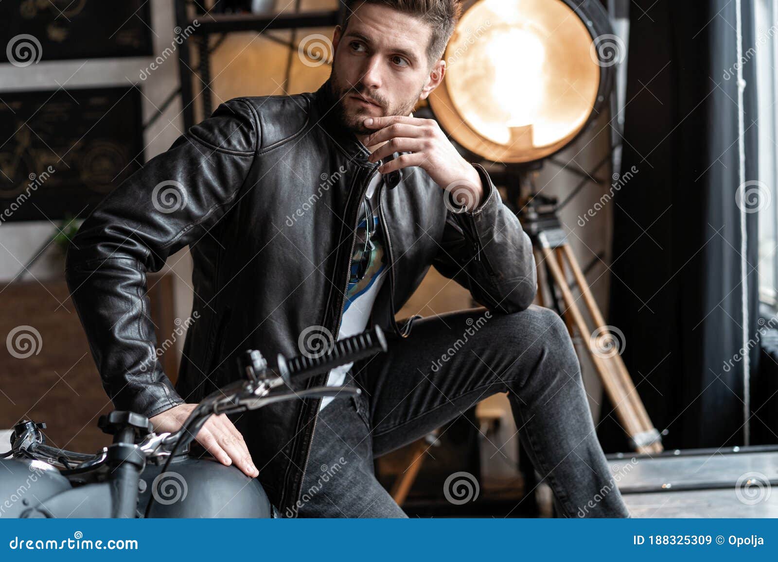 Handsome Young Man in Leather Jacket Looking Away while Sitting on the ...