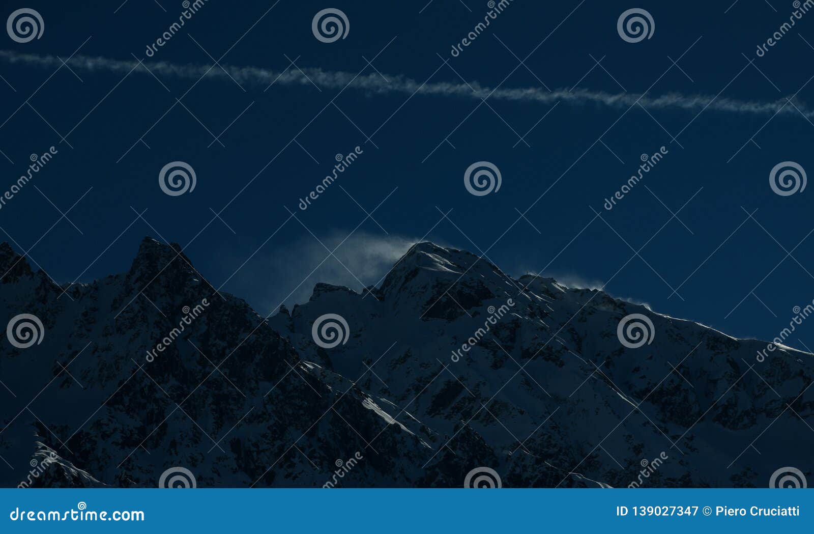 wind blowing over snow capped mountain peaks