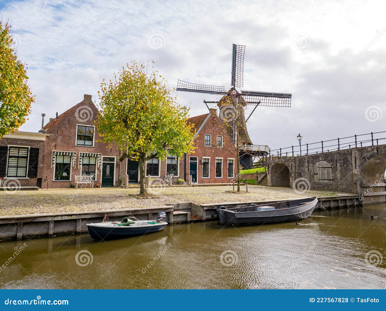 windmill de kaai, heerenwal with houses and canal in sloten, sleat, friesland, netherlands