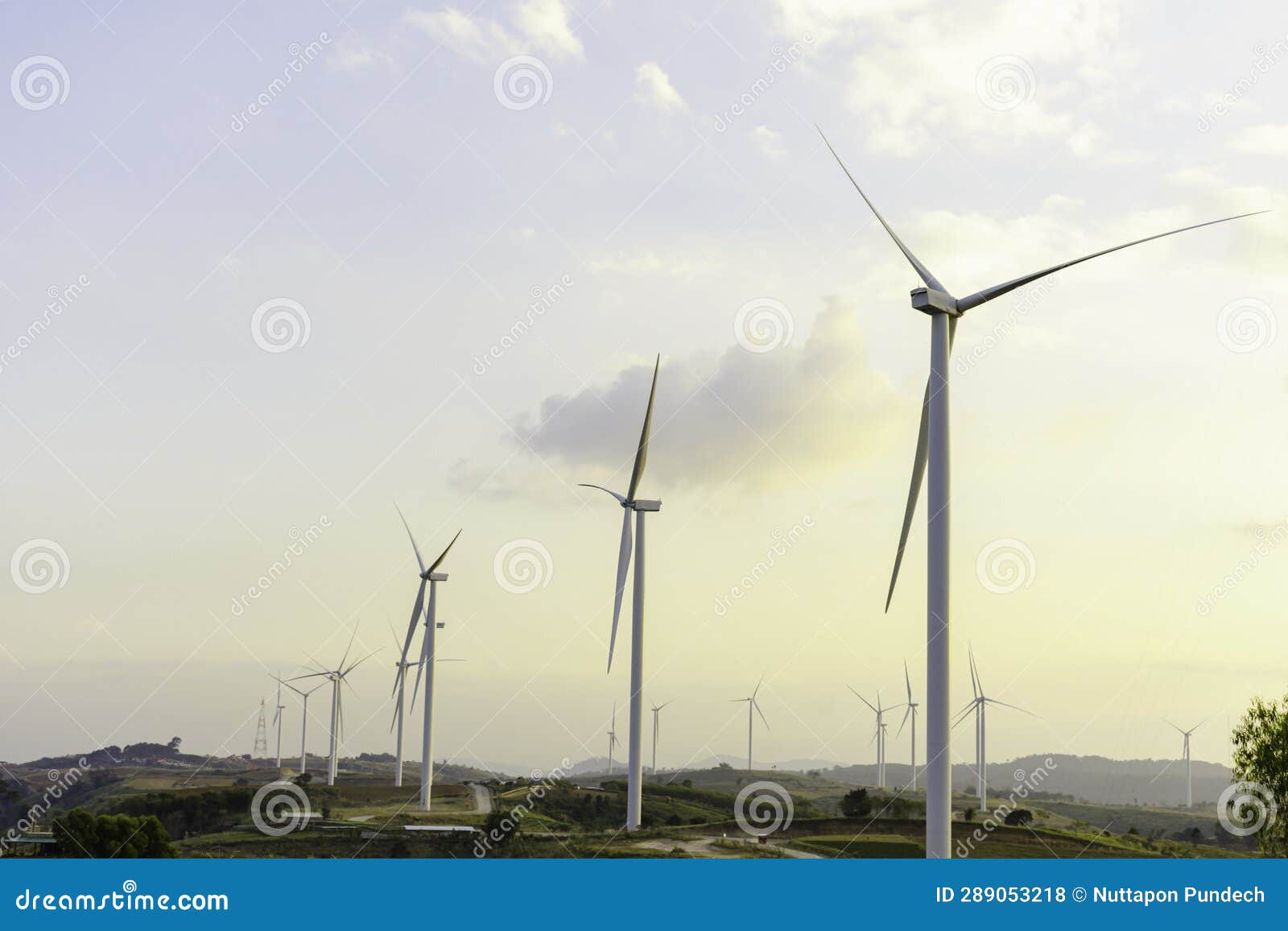 windmill turbine farm for electricity generation on landscape mountain at sunset sky