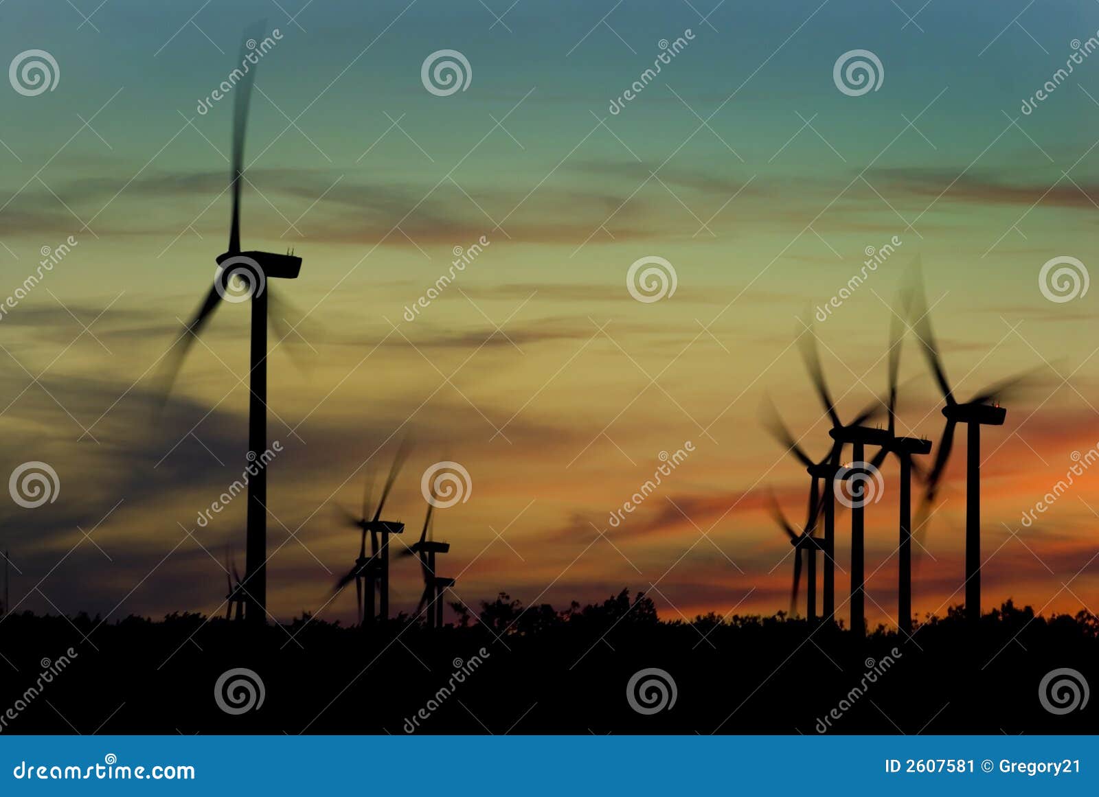 Het landbouwbedrijf van de wind met windmolens bij zonsondergang.