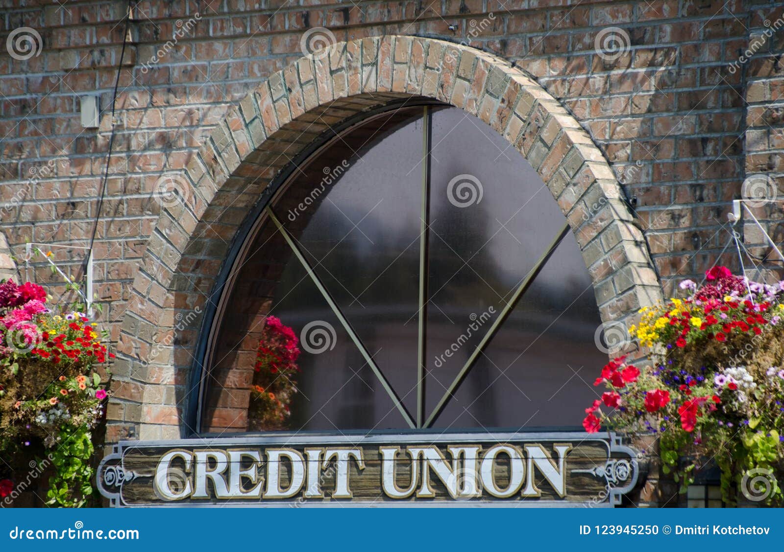window of a credit union surrounded by flower baskets