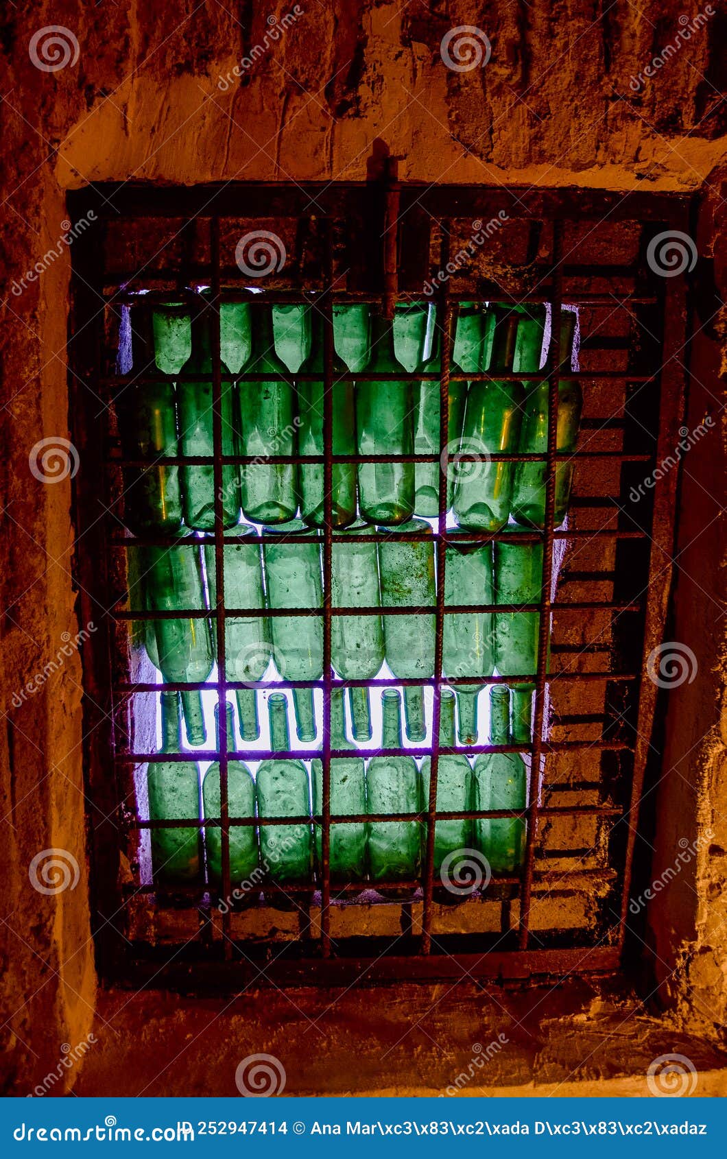 window of green wine bottles in a wine cellar