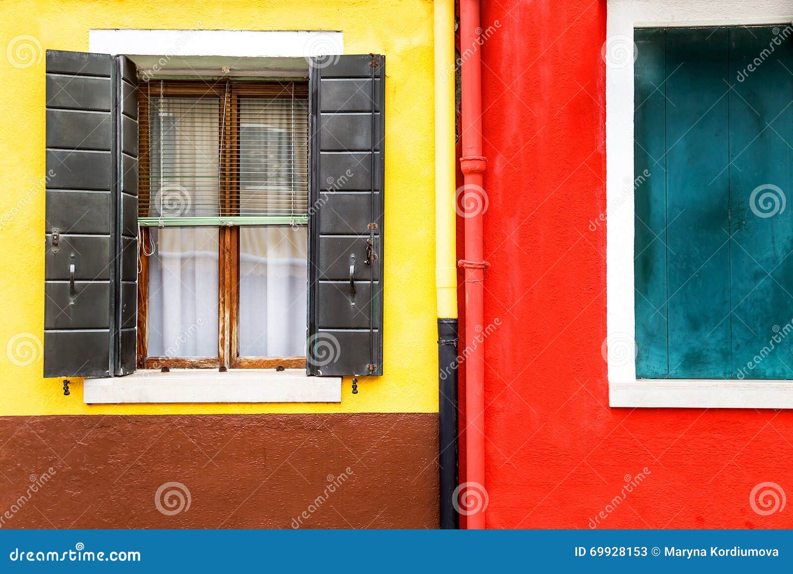 window with shutters open on a yellow and red wall background. copy space.