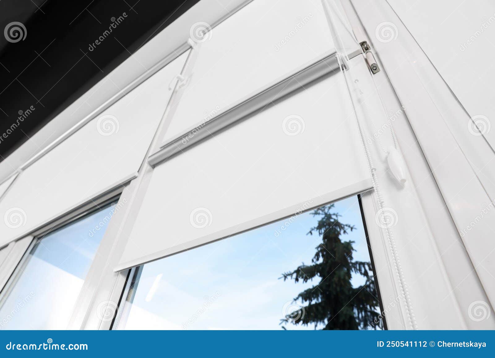 window with white roller blinds indoors, low angle view